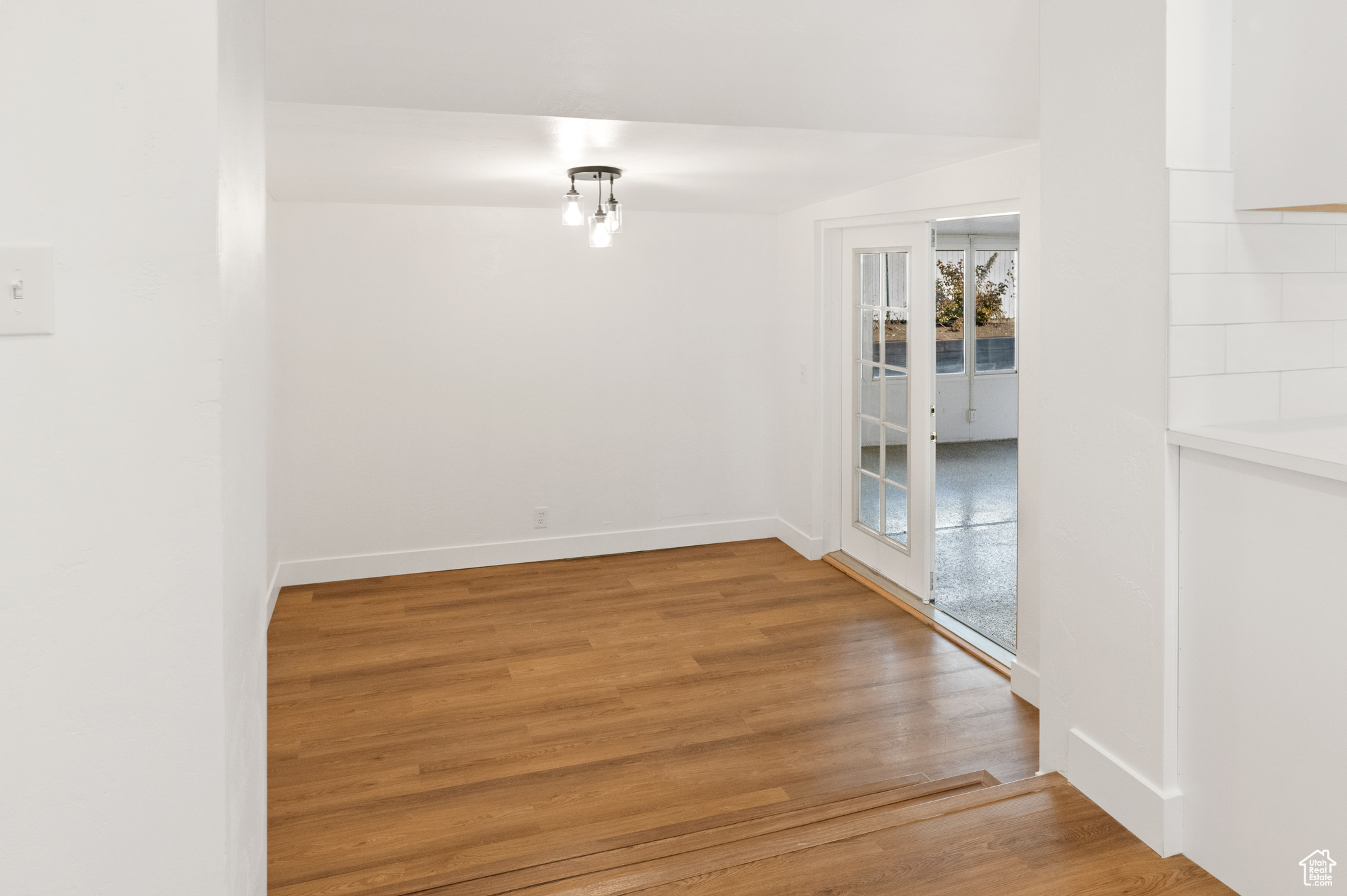 Unfurnished room featuring hardwood / wood-style floors and french doors