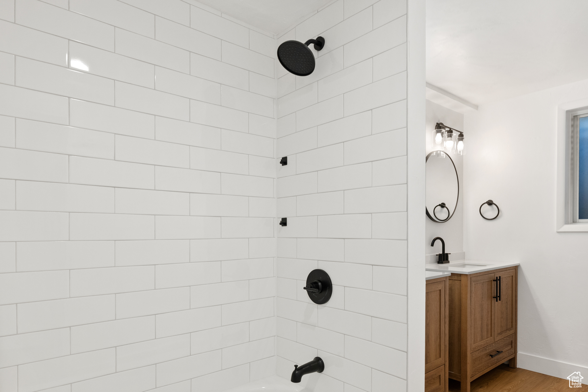 Bathroom featuring hardwood / wood-style floors, vanity, and tiled shower / bath combo