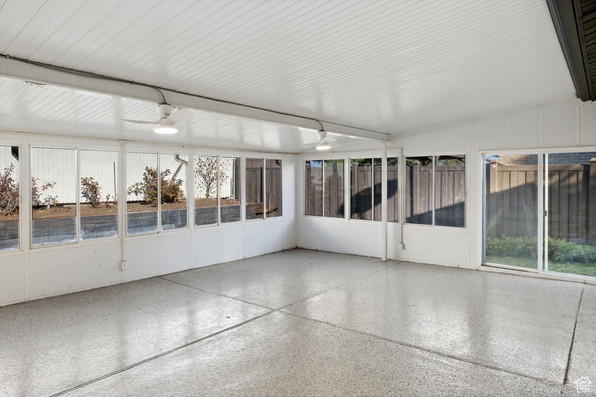 Unfurnished sunroom with vaulted ceiling and ceiling fan