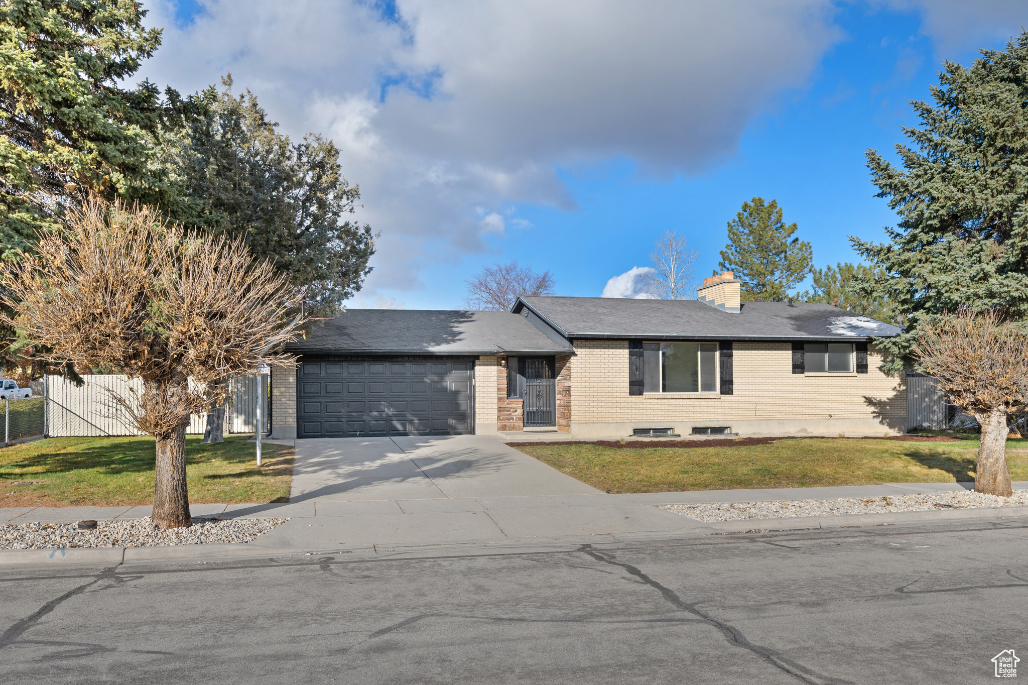 Ranch-style home featuring a front lawn and a garage