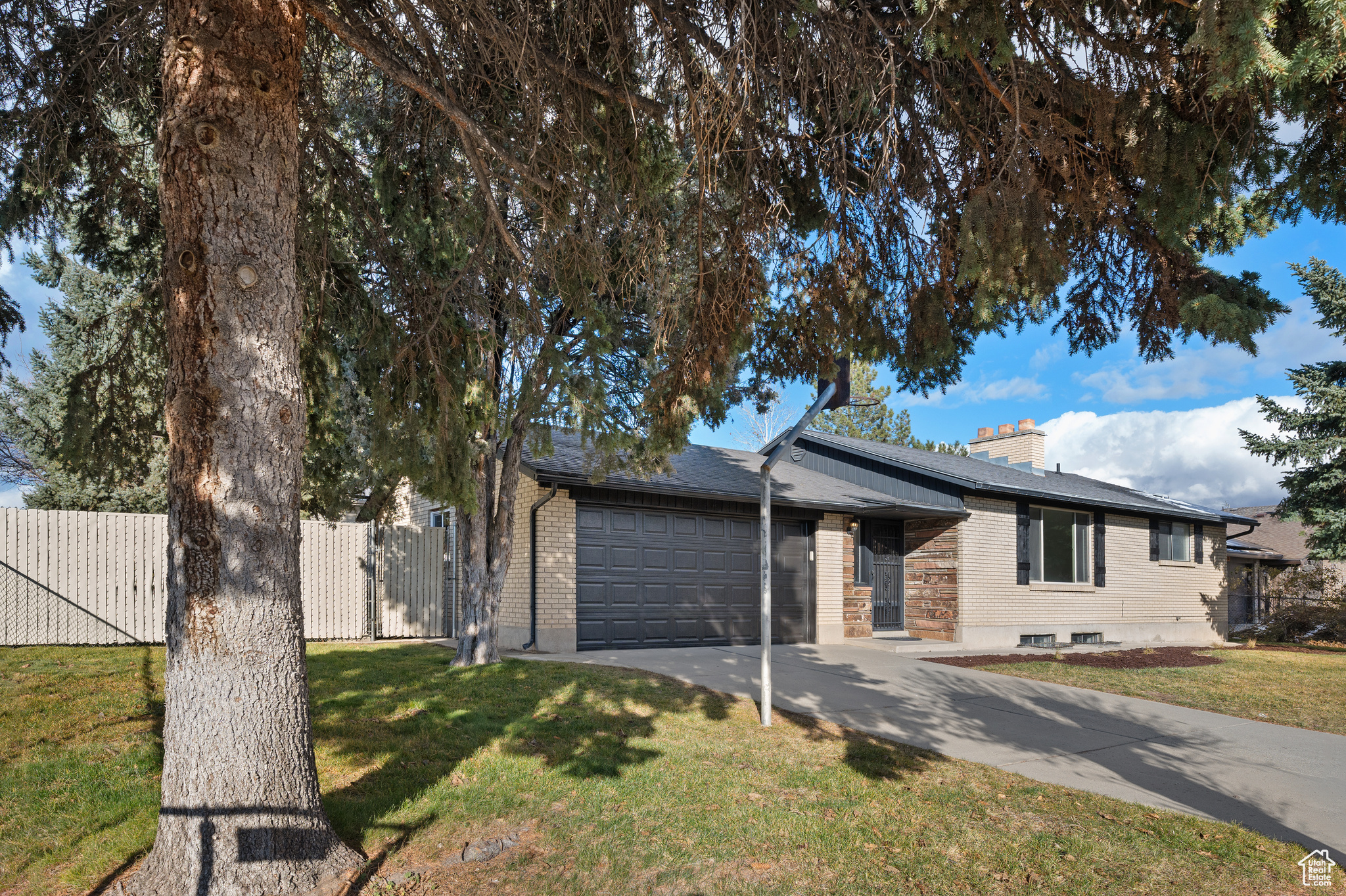 Ranch-style house with a garage and a front lawn