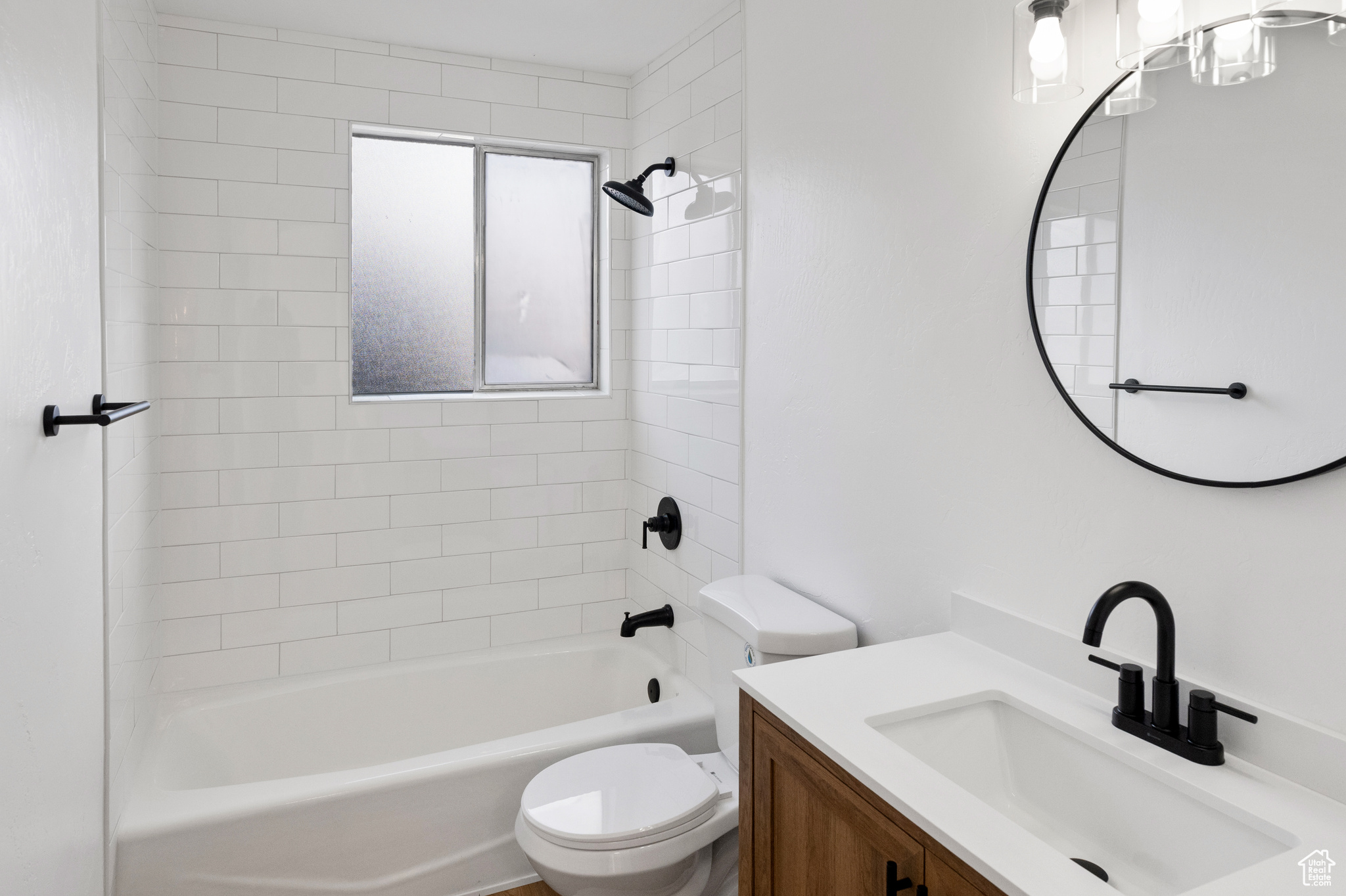 Full bathroom with tiled shower / bath, vanity, and toilet