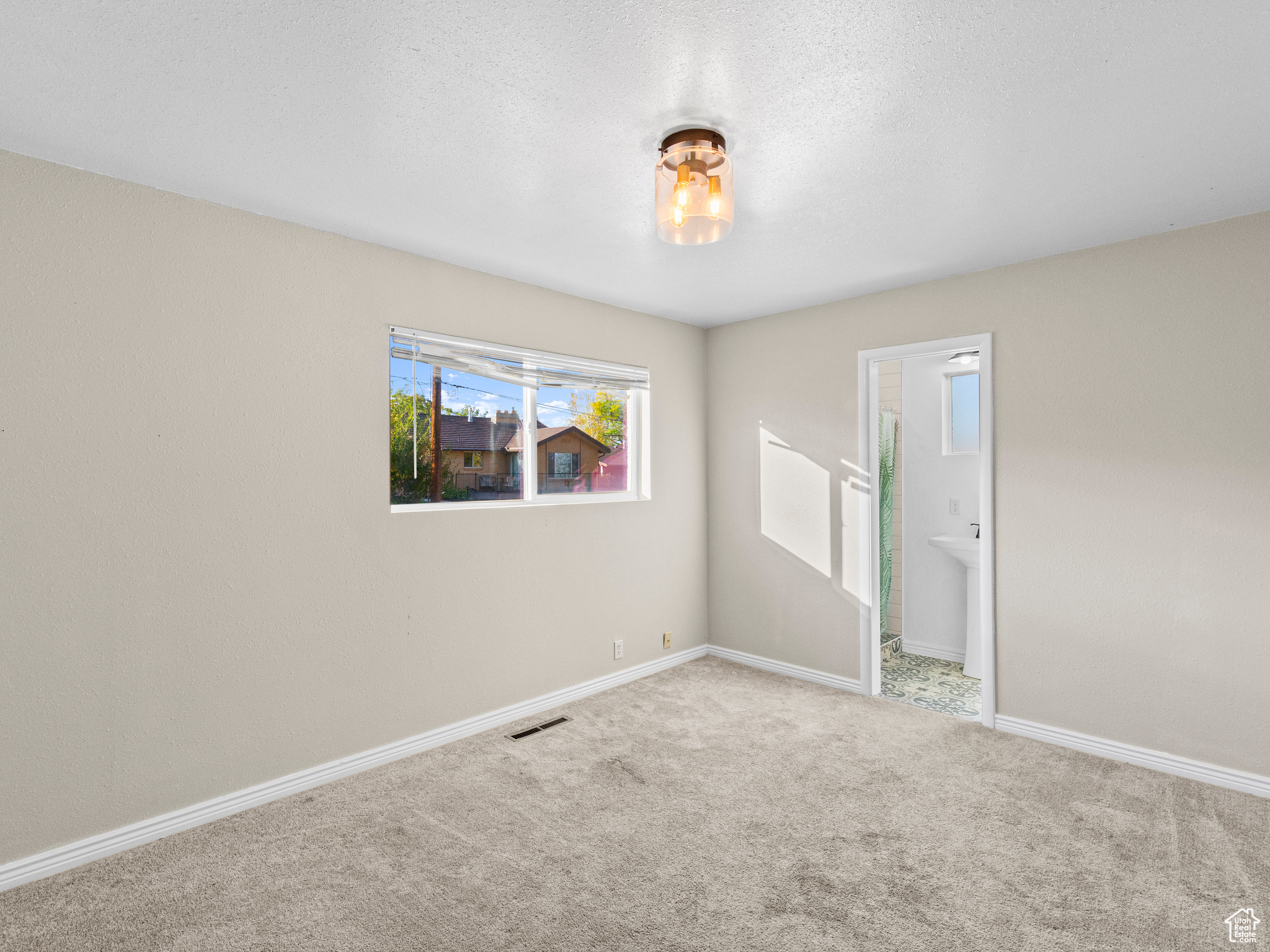 Carpeted spare room featuring a textured ceiling