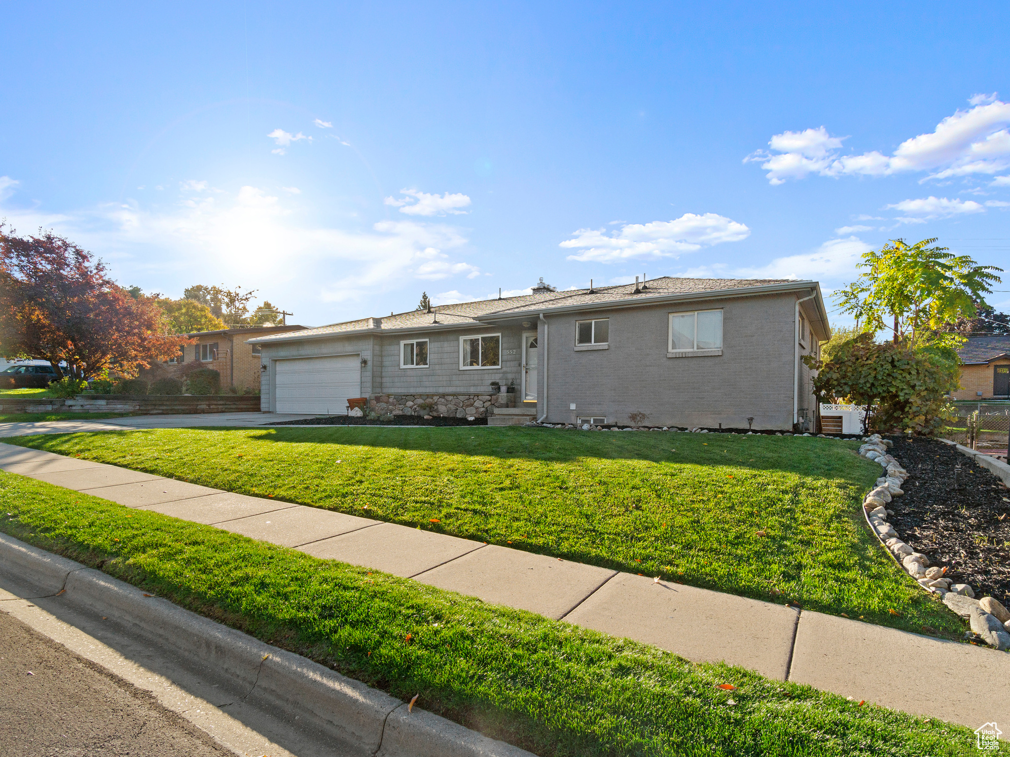 Single story home with a garage and a front yard