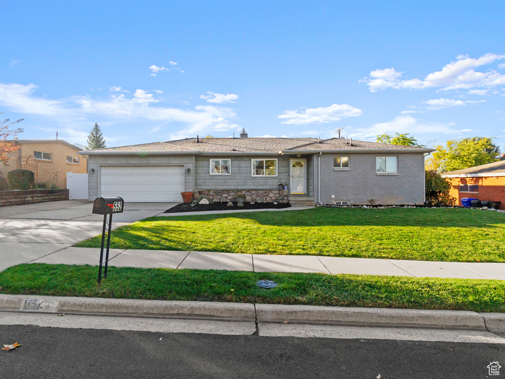 Single story home featuring a garage and a front lawn