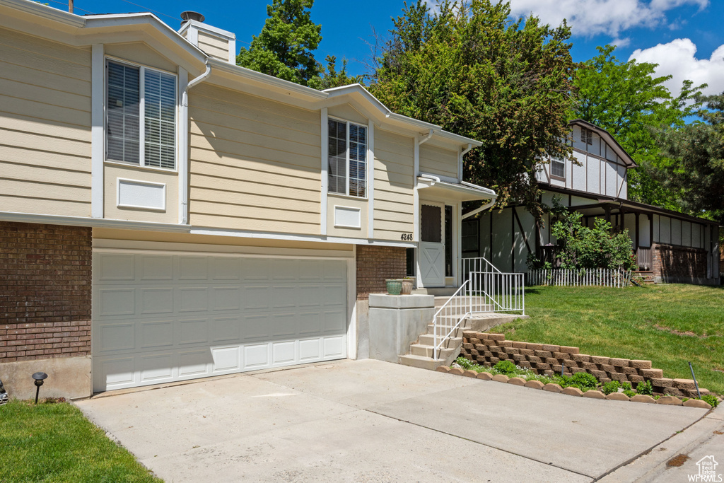 View of front facade with a front lawn and a garage