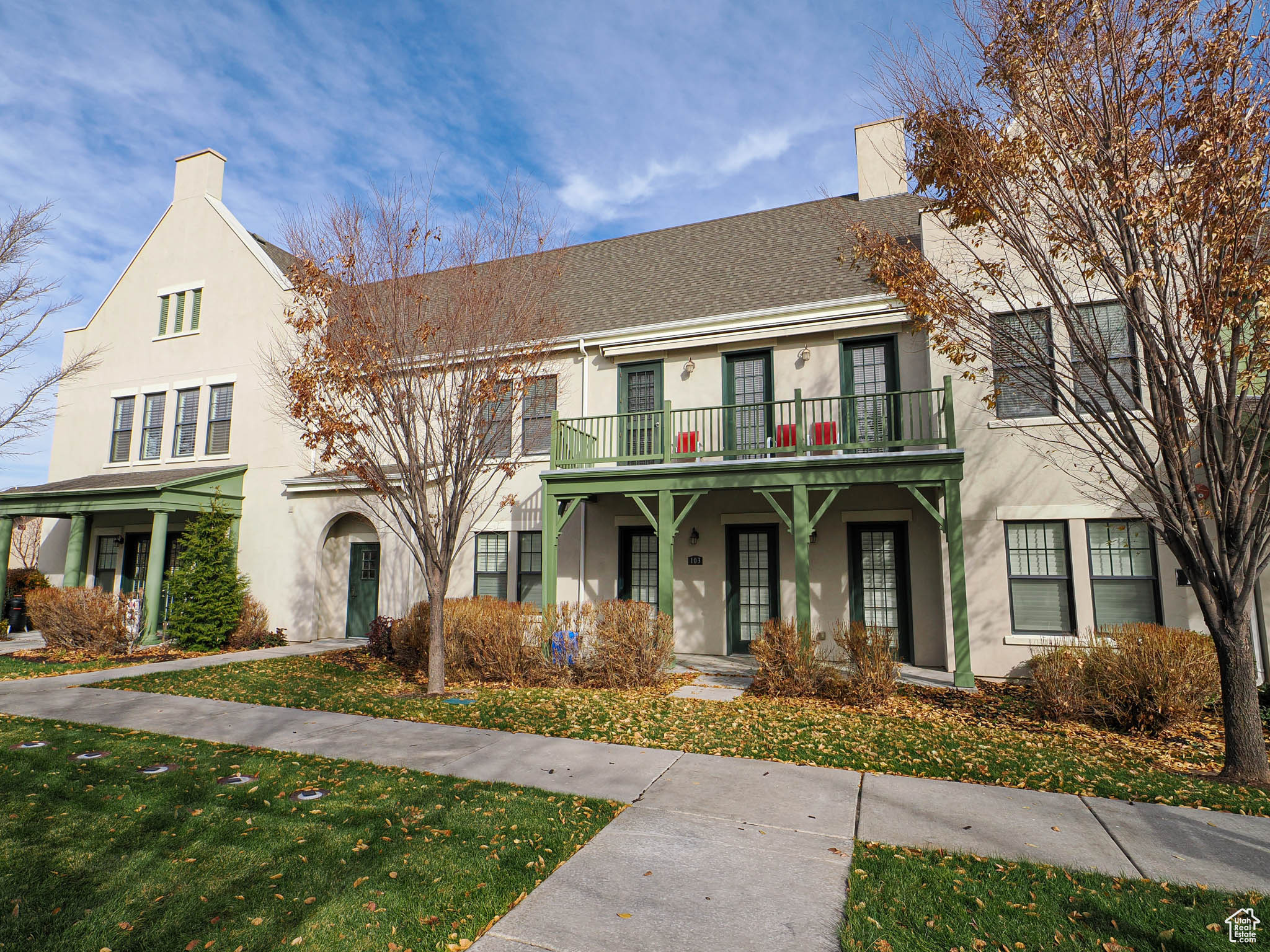 View of front of house with a balcony and a front lawn