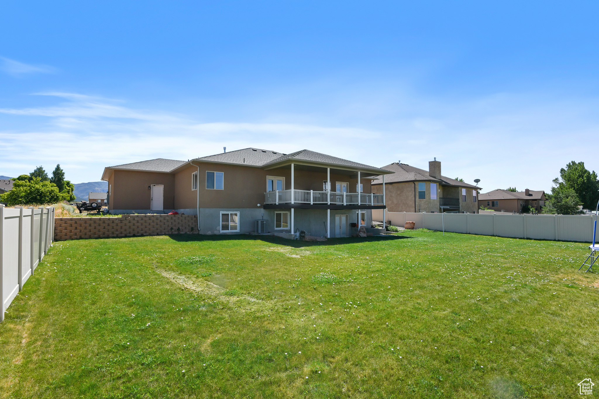 Back of property featuring cooling unit and a yard