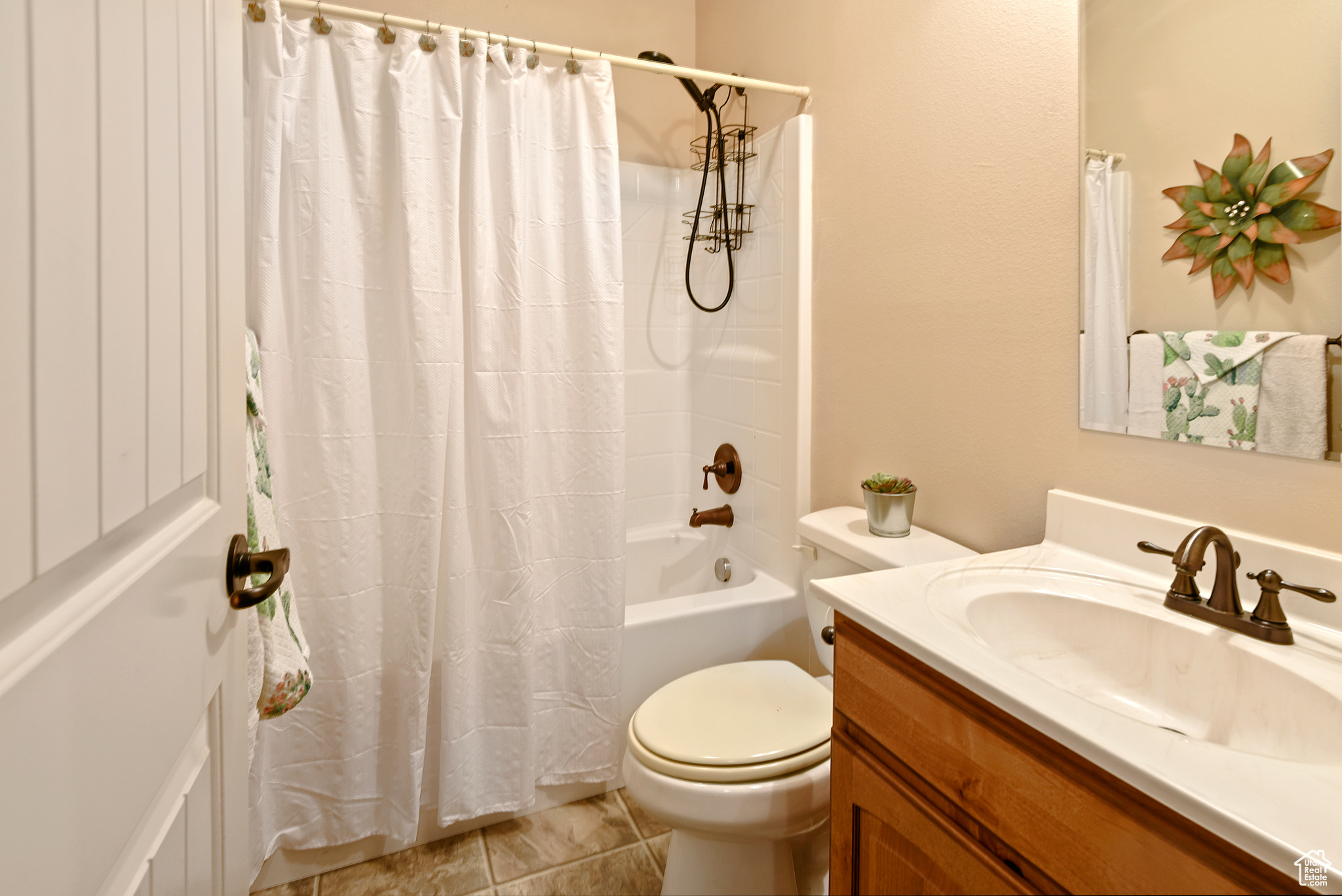 Full bathroom with tile patterned flooring, vanity, shower / tub combo, and toilet