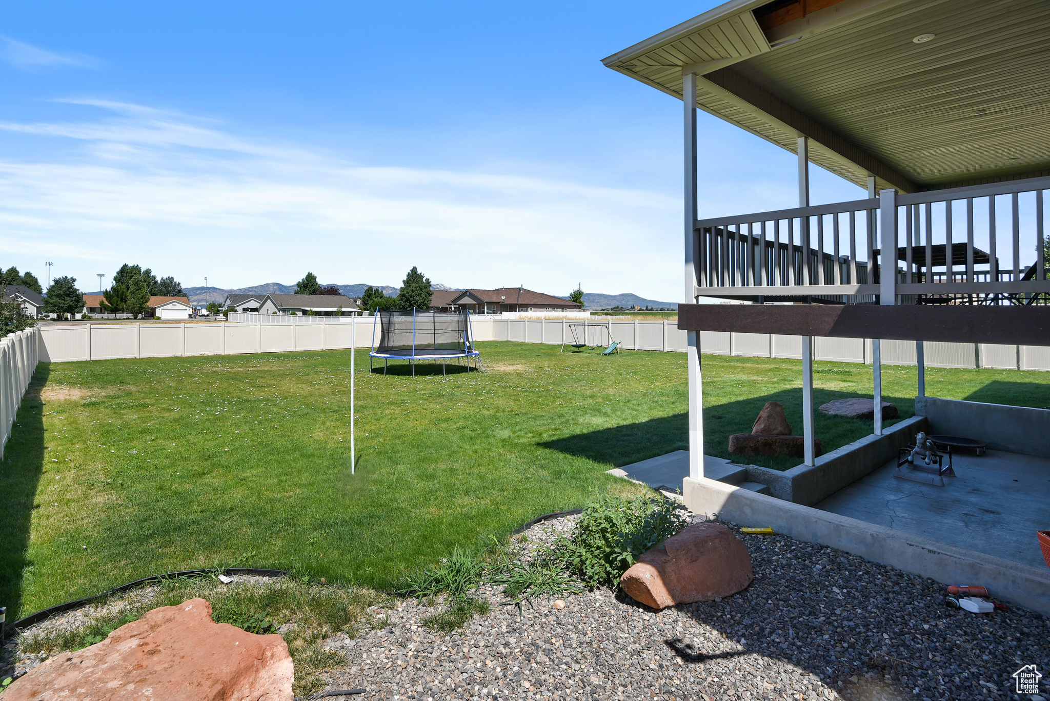 View of yard with a patio area, a deck, and a trampoline