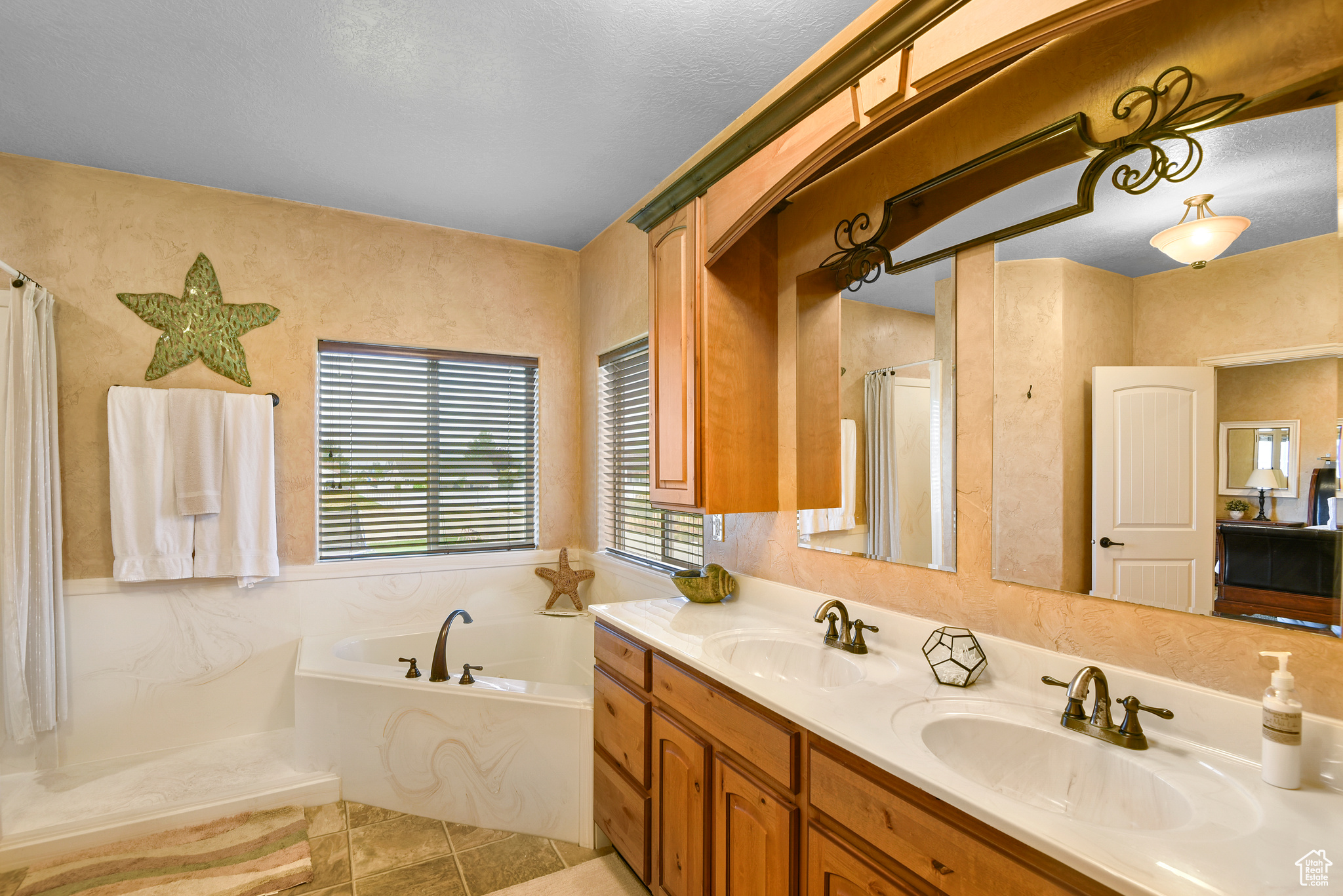 Bathroom featuring tile patterned flooring, vanity, and plus walk in shower