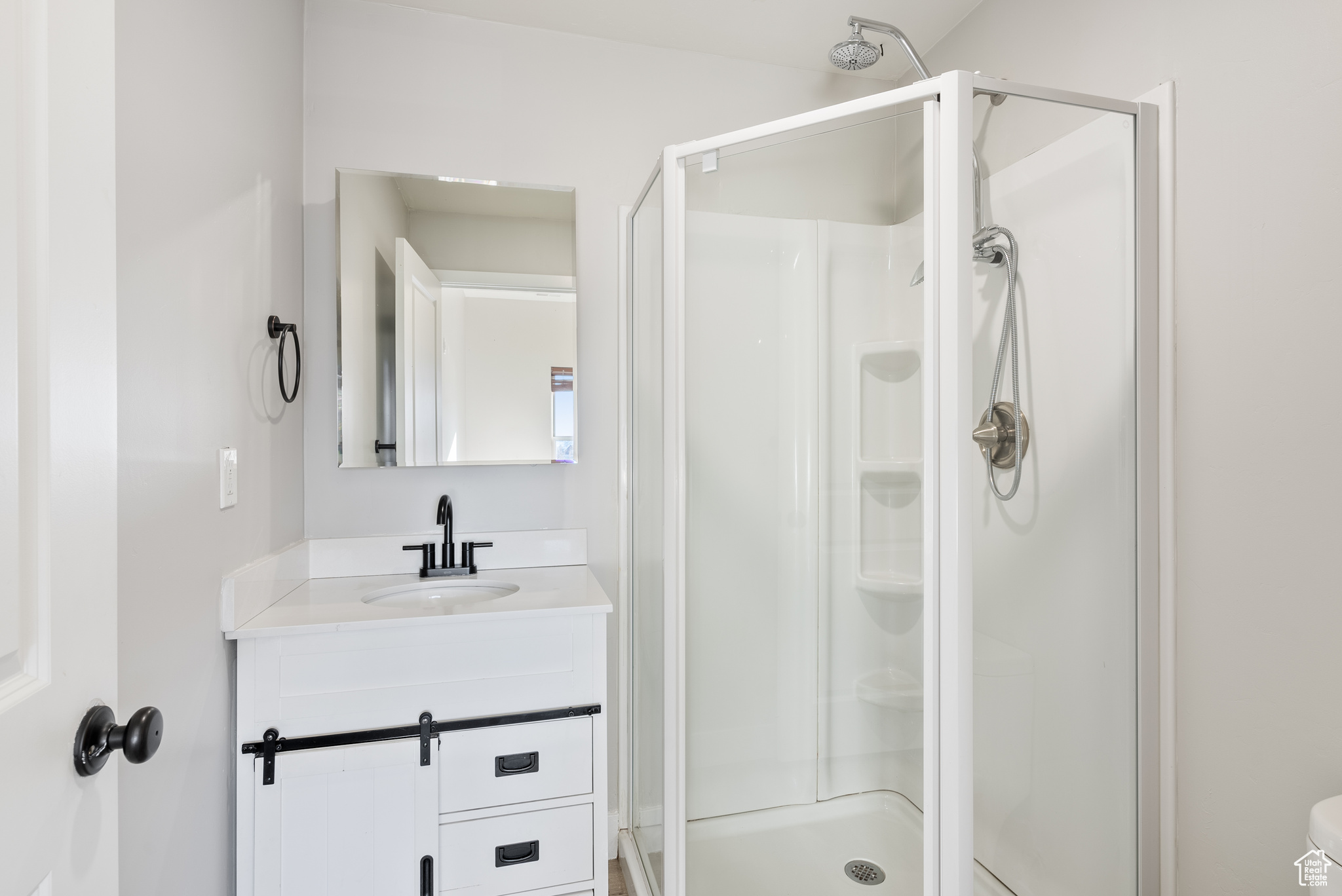 Bathroom with vanity, toilet, and a shower with shower door