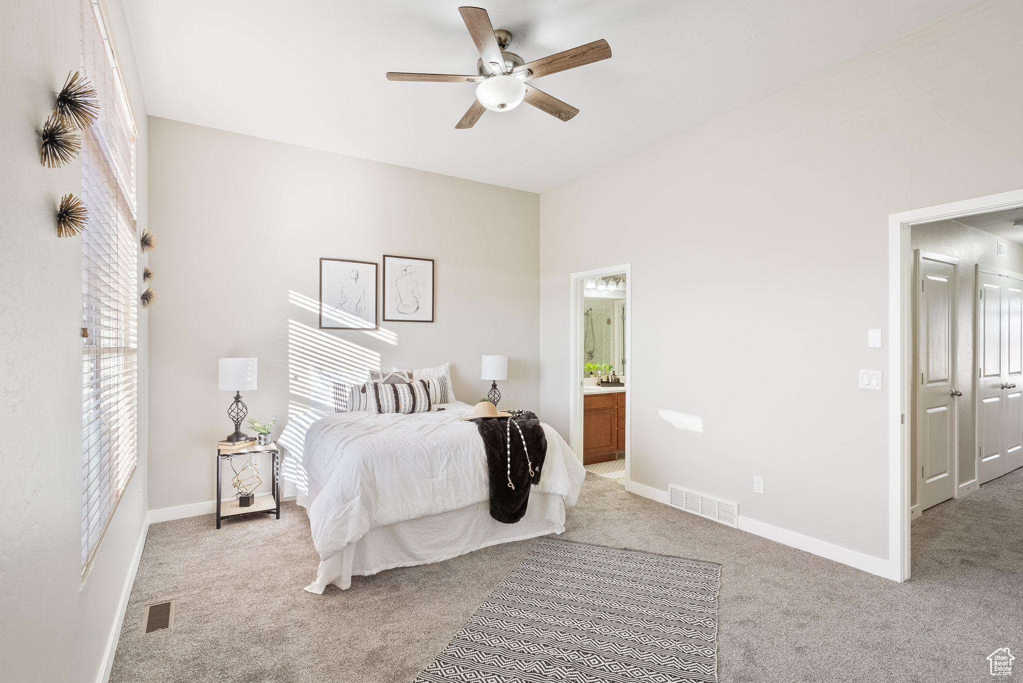 Carpeted bedroom with ceiling fan and connected bathroom