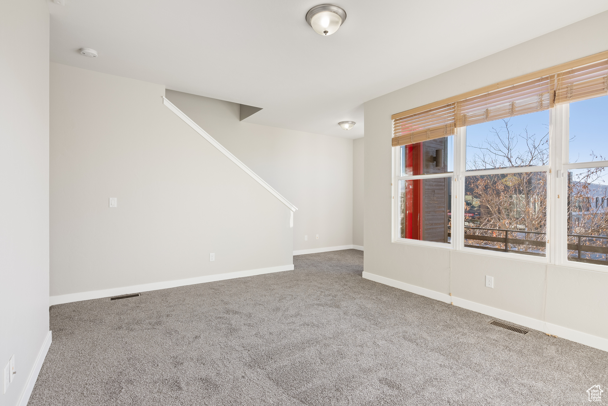 Spare room featuring carpet floors and a healthy amount of sunlight