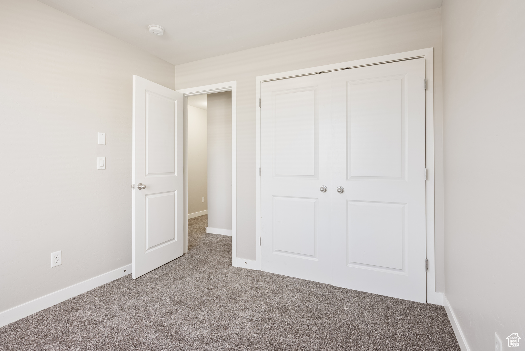 Unfurnished bedroom with a closet and light colored carpet