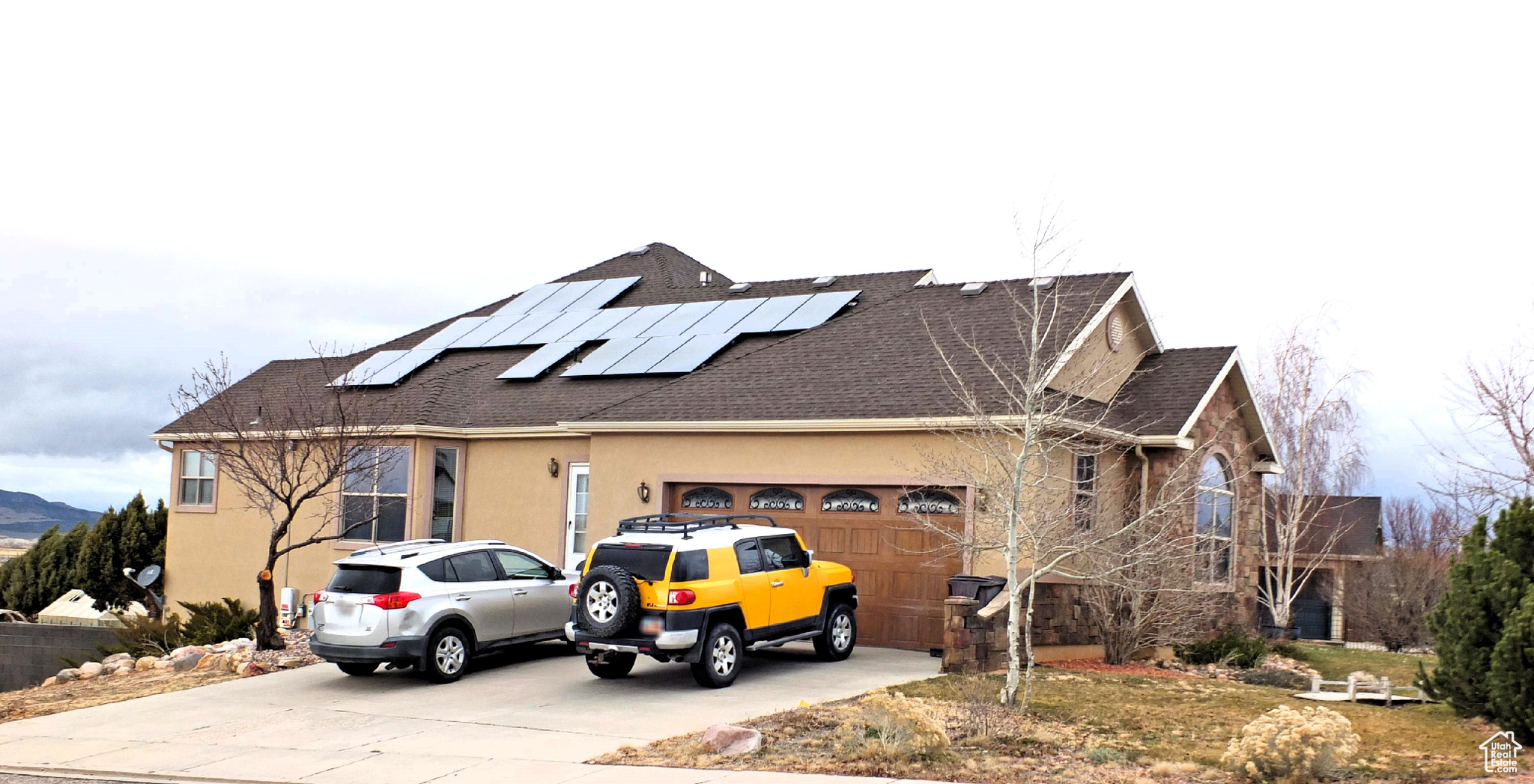 View of front facade with solar panels and a garage