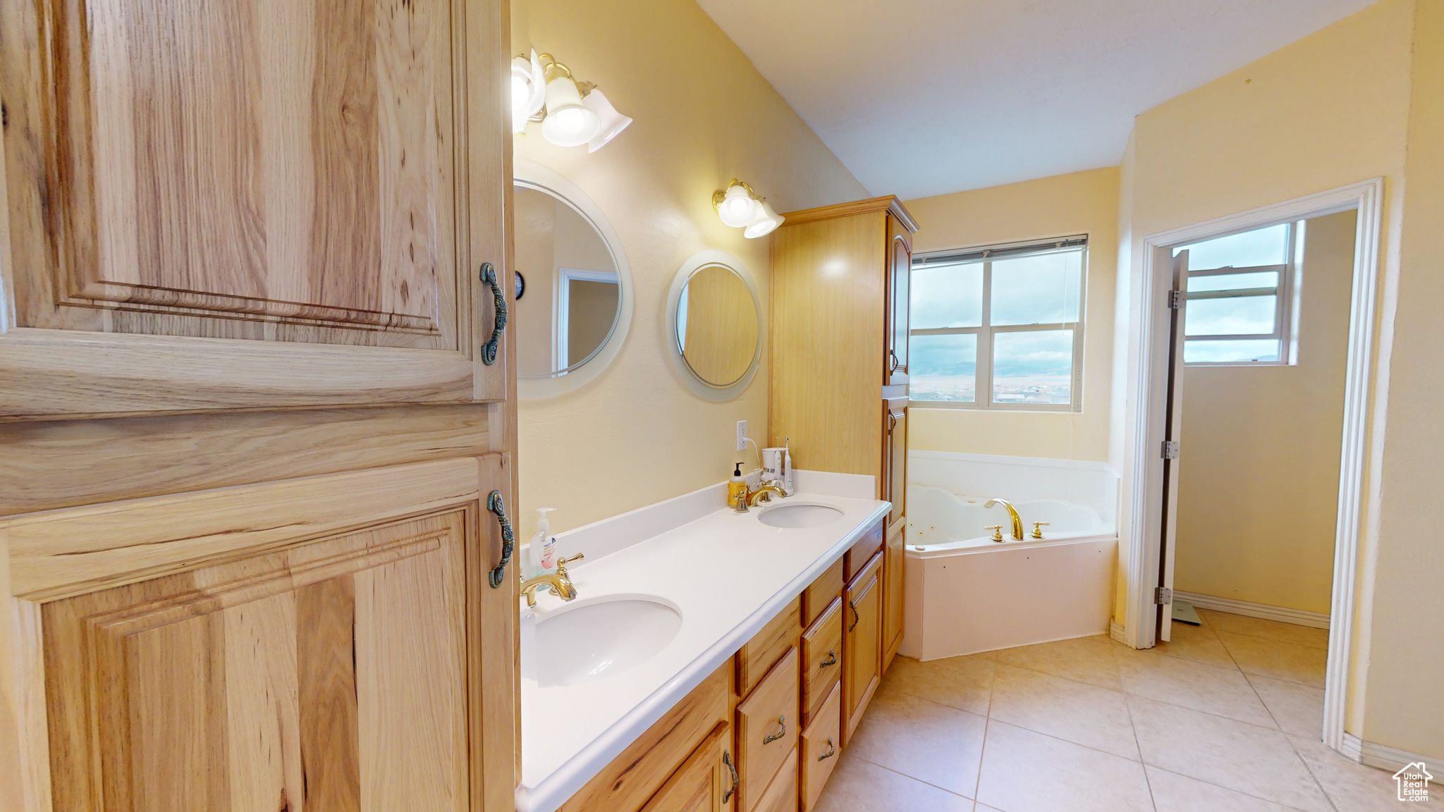 Bathroom featuring a bath, vanity, and tile patterned floors