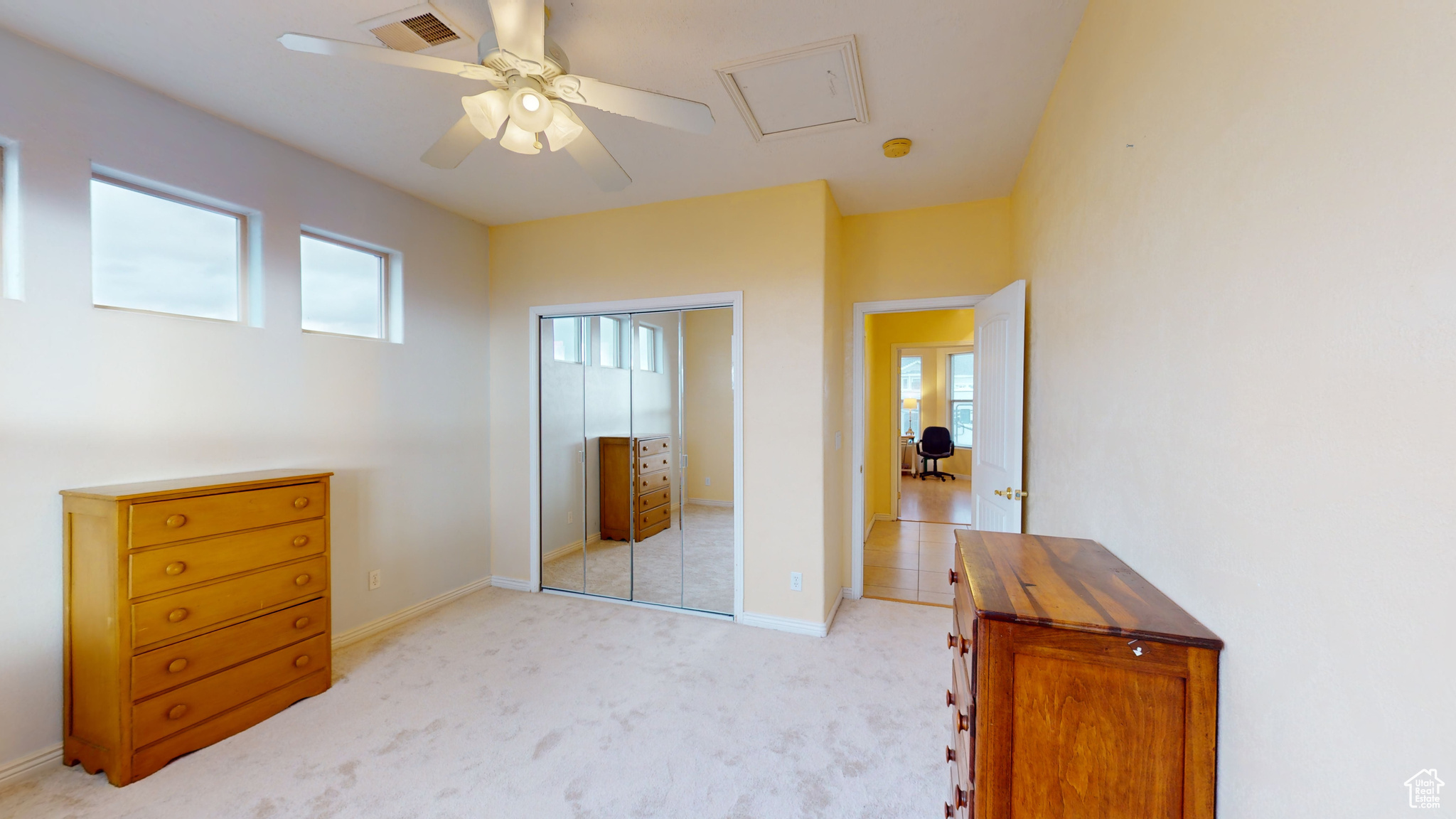 Carpeted bedroom with a closet and ceiling fan