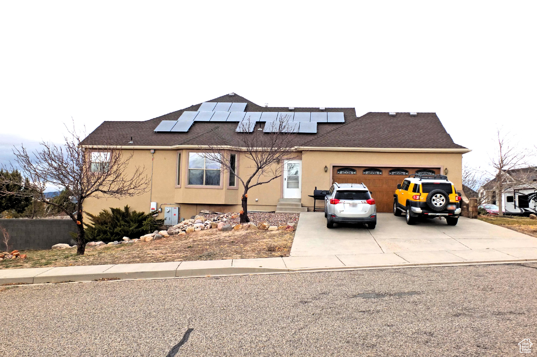 View of front of house with solar panels and a garage