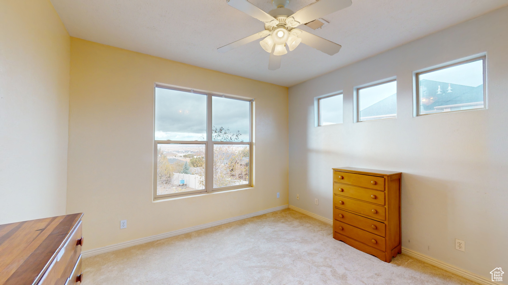 Carpeted empty room featuring ceiling fan