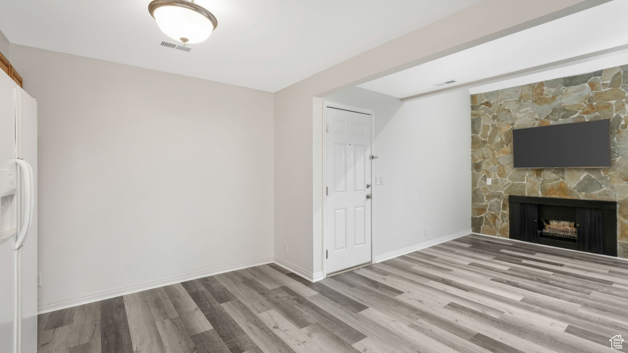 Unfurnished living room featuring a fireplace and light hardwood / wood-style floors