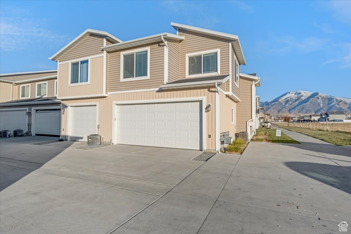 View of back of property with a mountain view and a garage