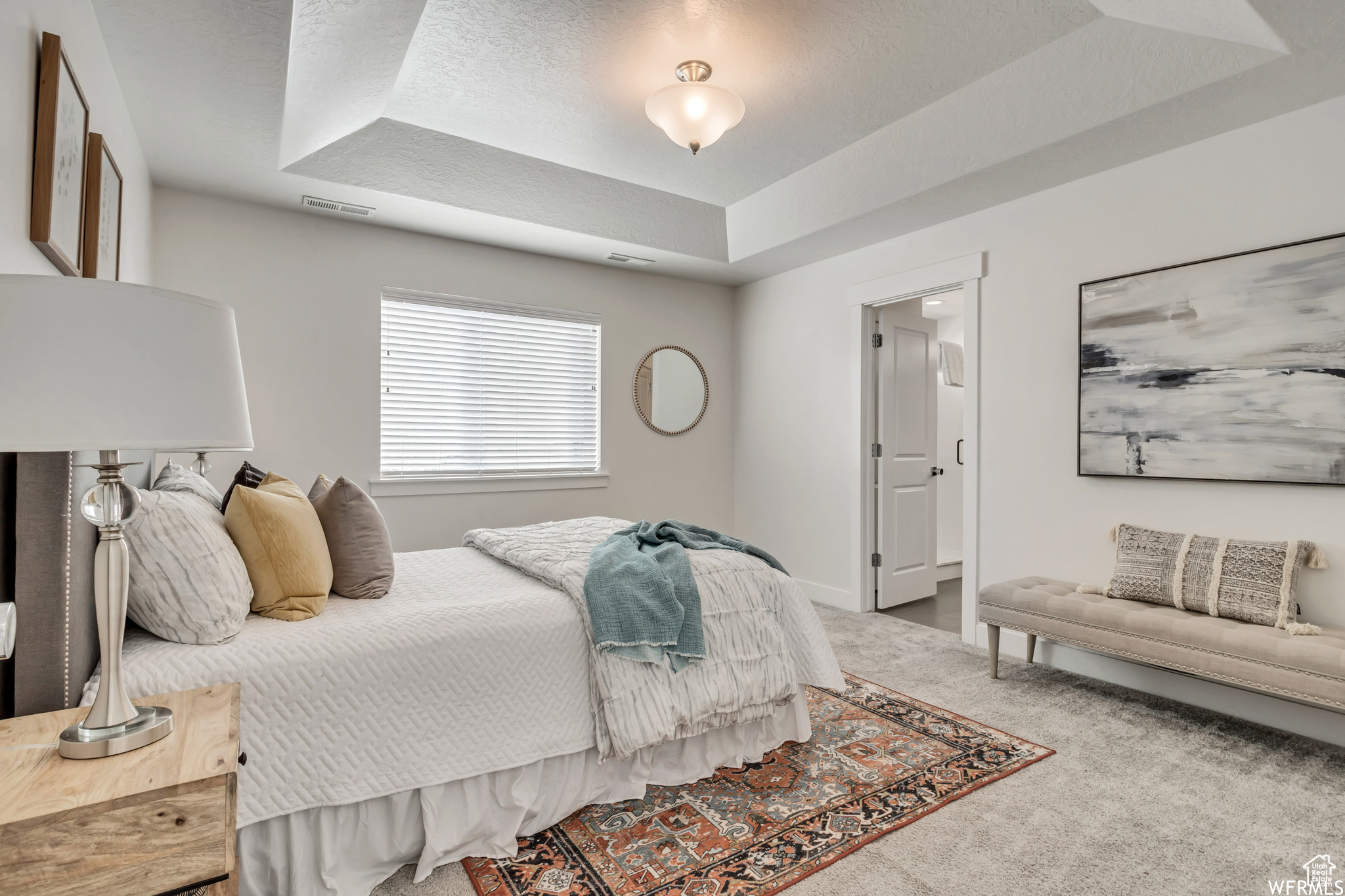 Carpeted bedroom featuring a raised ceiling