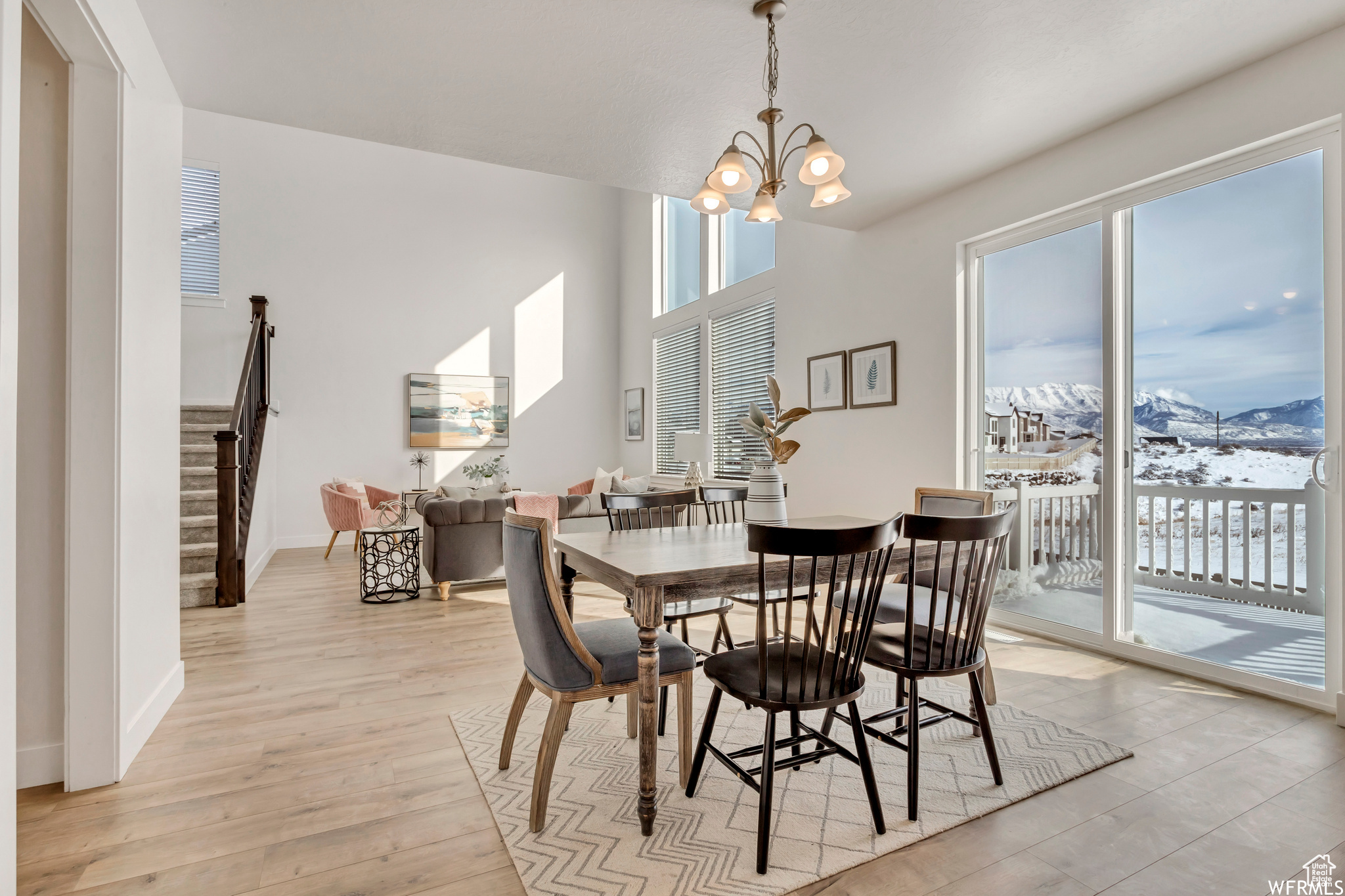 Dining area with a mountain view, an inviting chandelier, and light hardwood / wood-style flooring