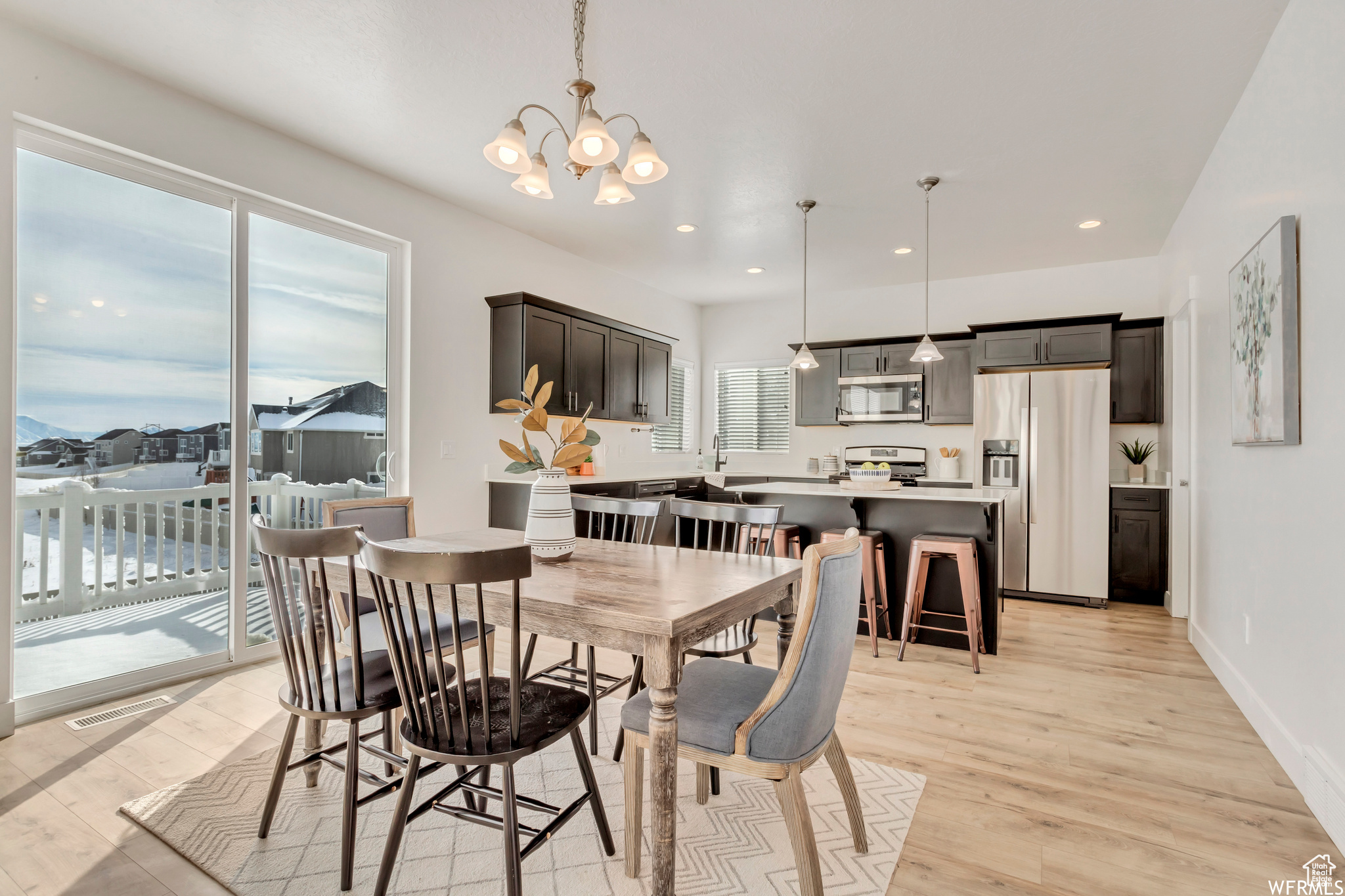 Dining space with a chandelier and light hardwood / wood-style floors