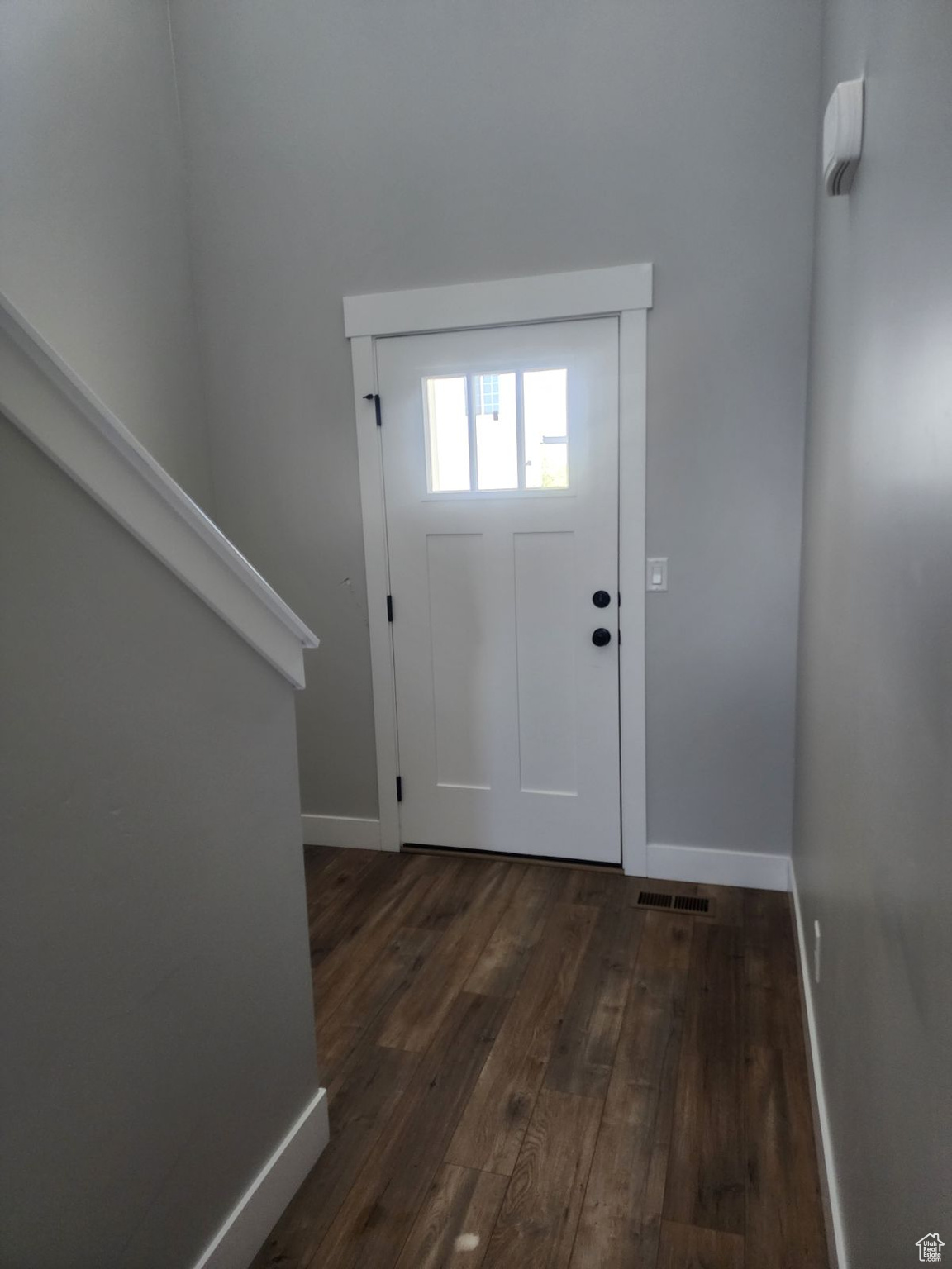 Entrance foyer with dark hardwood / wood-style floors