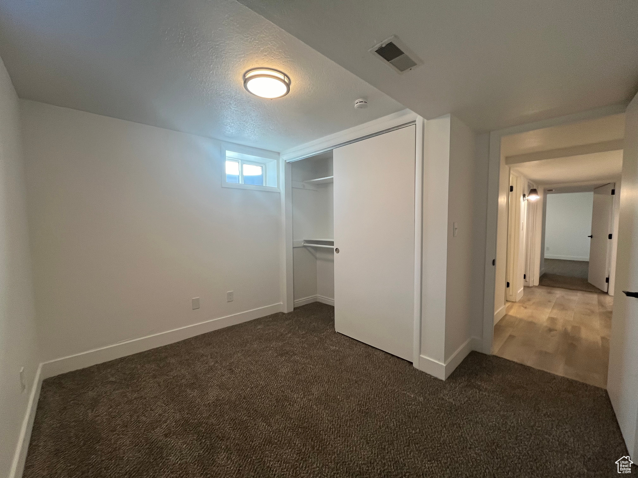 Unfurnished bedroom featuring a closet, carpet floors, and a textured ceiling