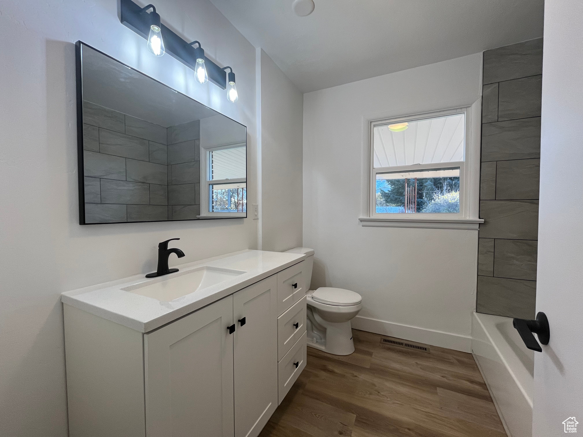 Bathroom featuring hardwood / wood-style floors, vanity, and toilet