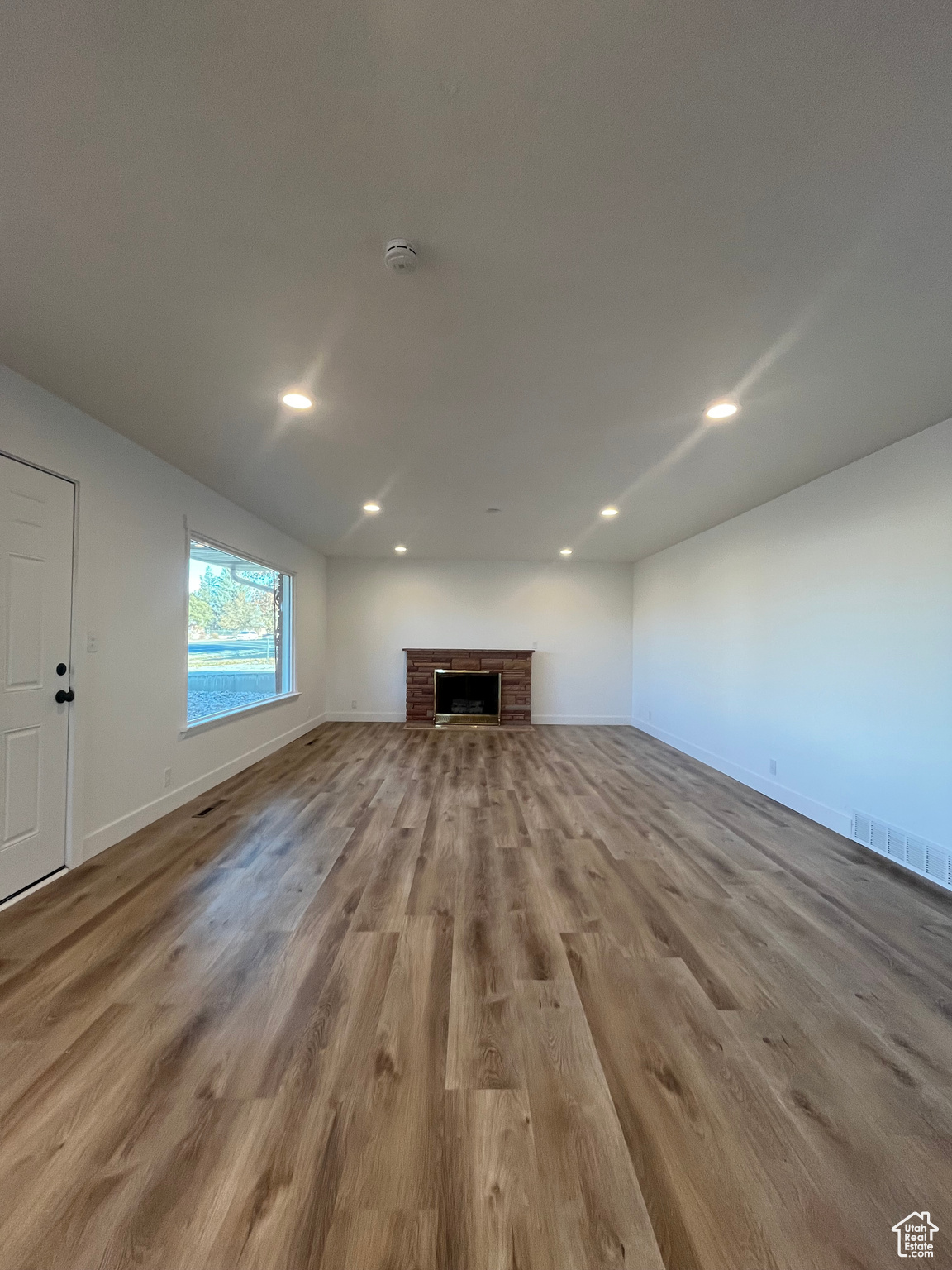 Unfurnished living room featuring light hardwood / wood-style floors and a fireplace