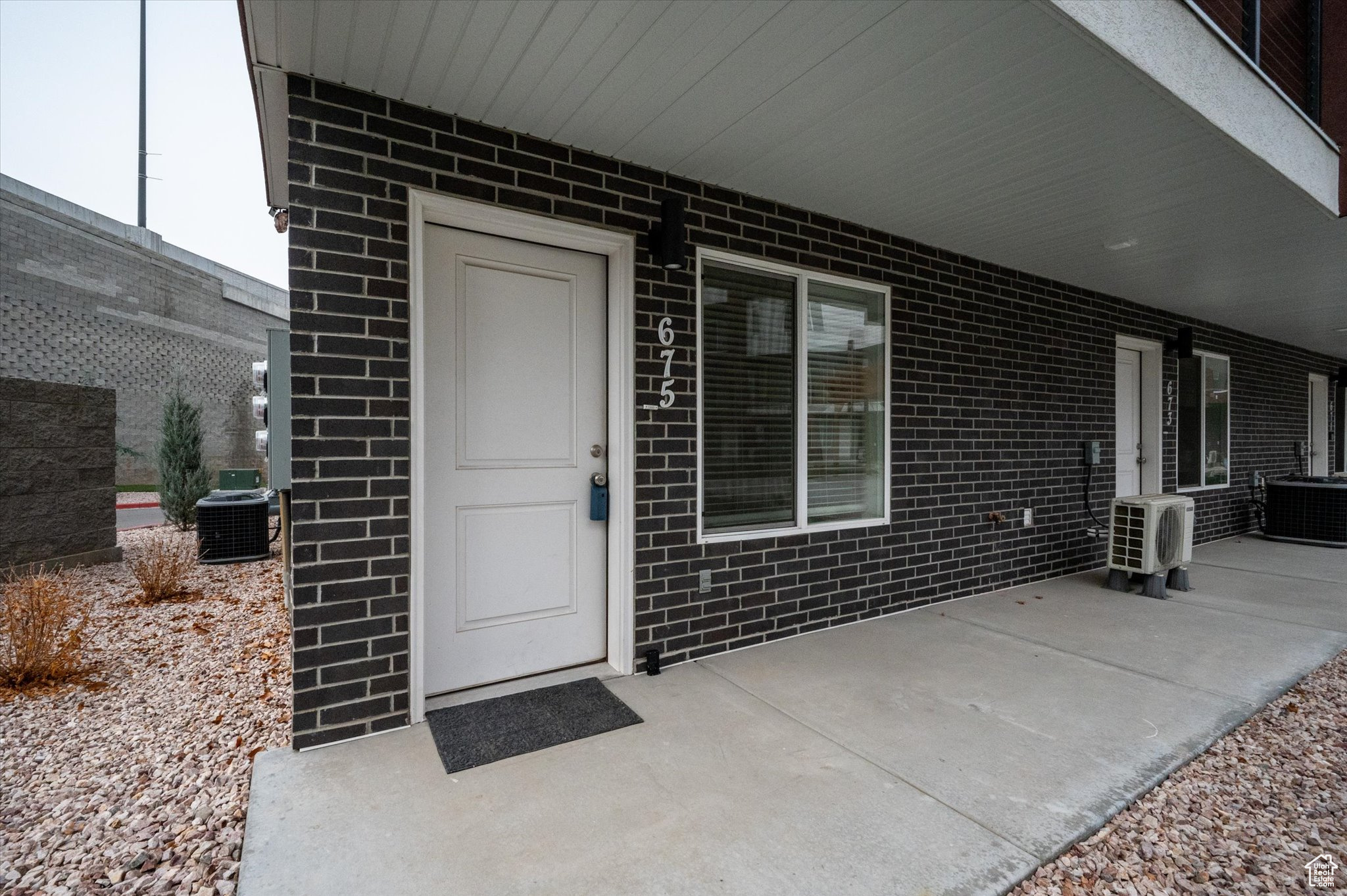 View of exterior entry with central AC unit