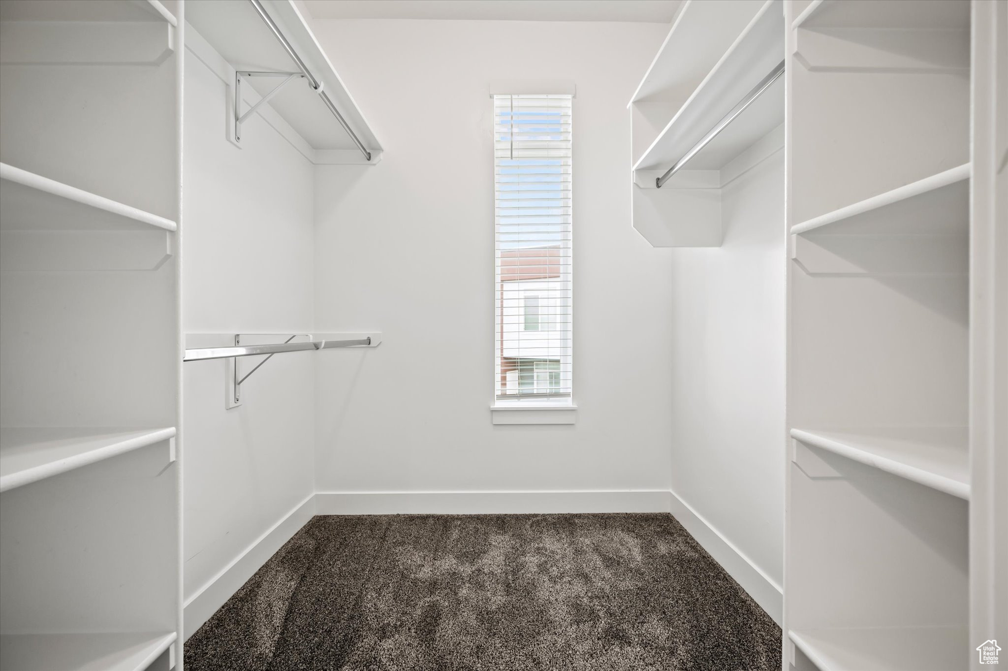 Walk in closet with dark carpet