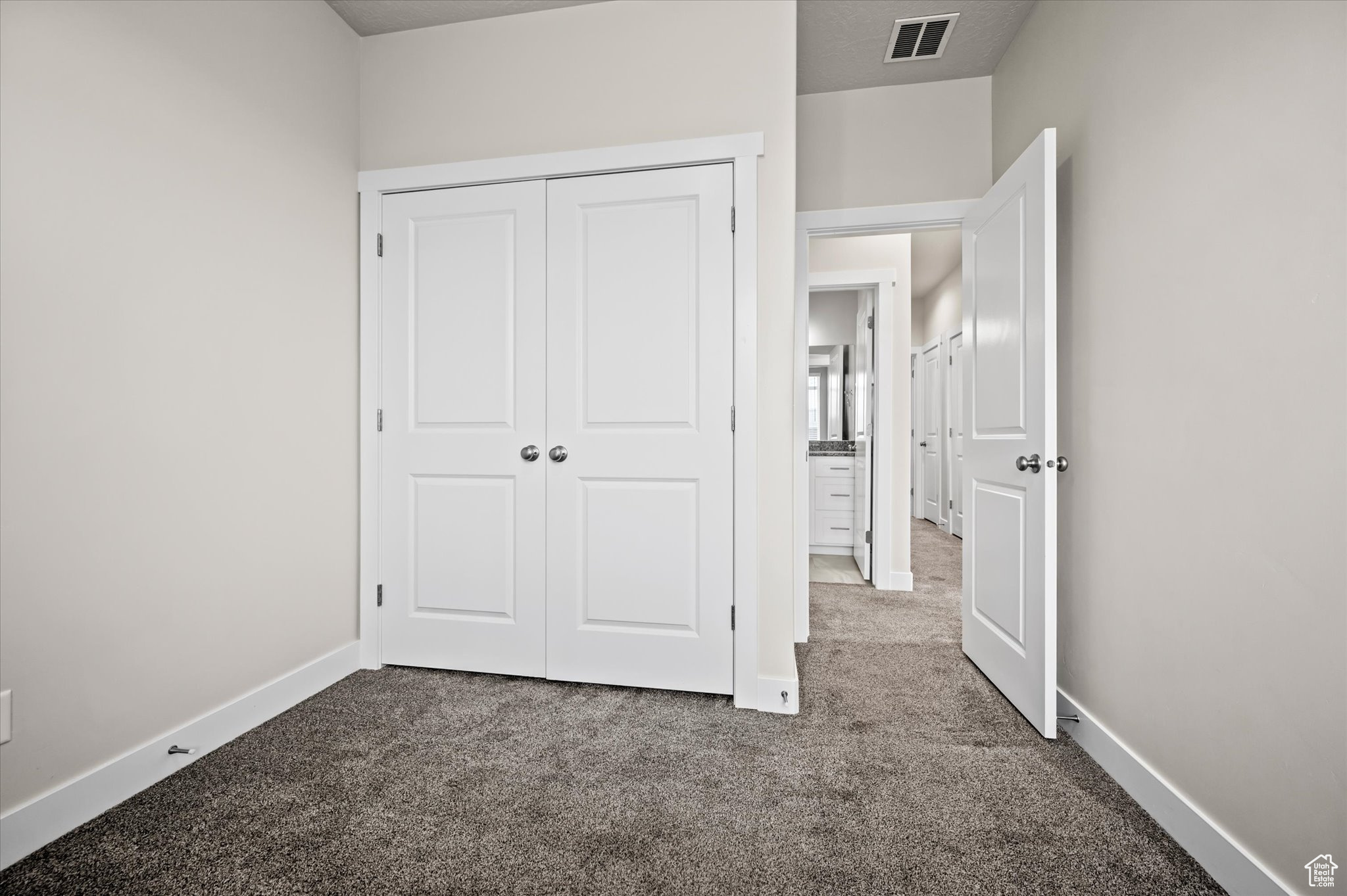 Unfurnished bedroom featuring a closet and carpet floors