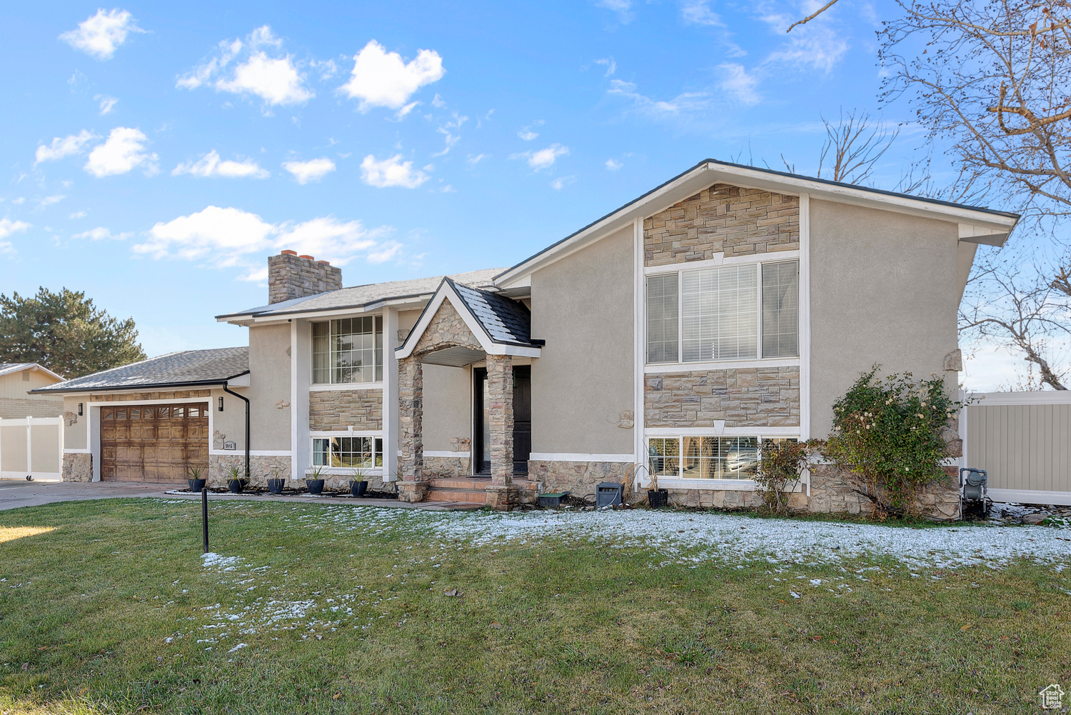 View of front of home with a garage and a front lawn