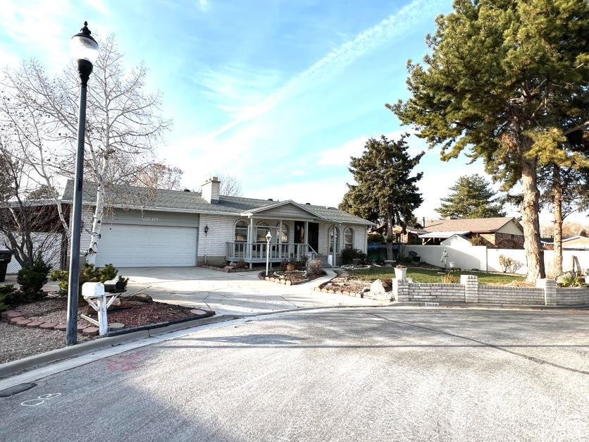 Single story home featuring a porch and a garage