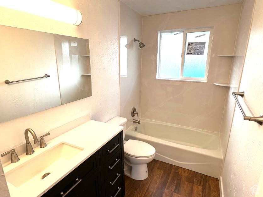 Full bathroom featuring hardwood / wood-style floors, vanity, toilet, and shower / bathtub combination