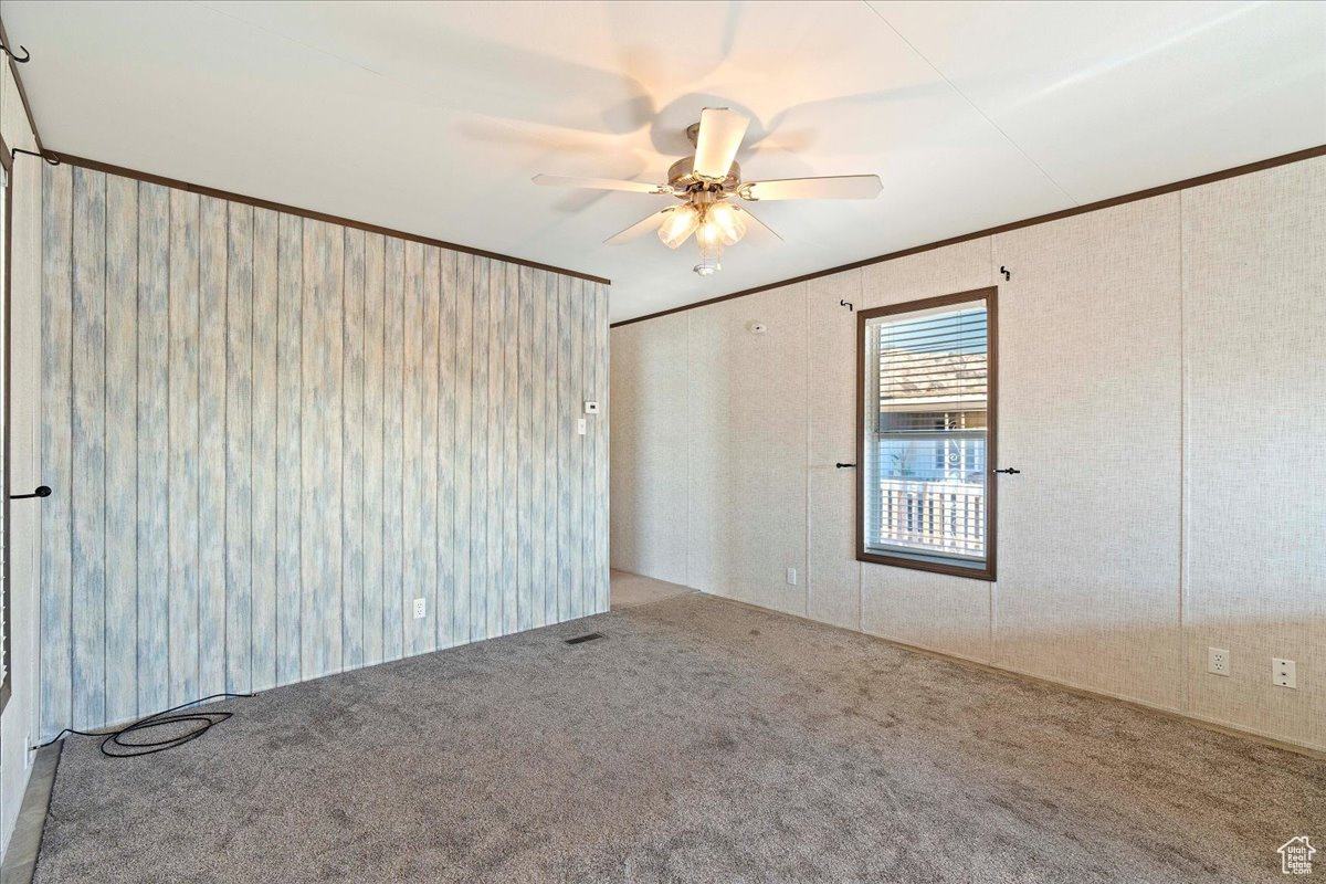 Unfurnished room with crown molding, carpet floors, and ceiling fan