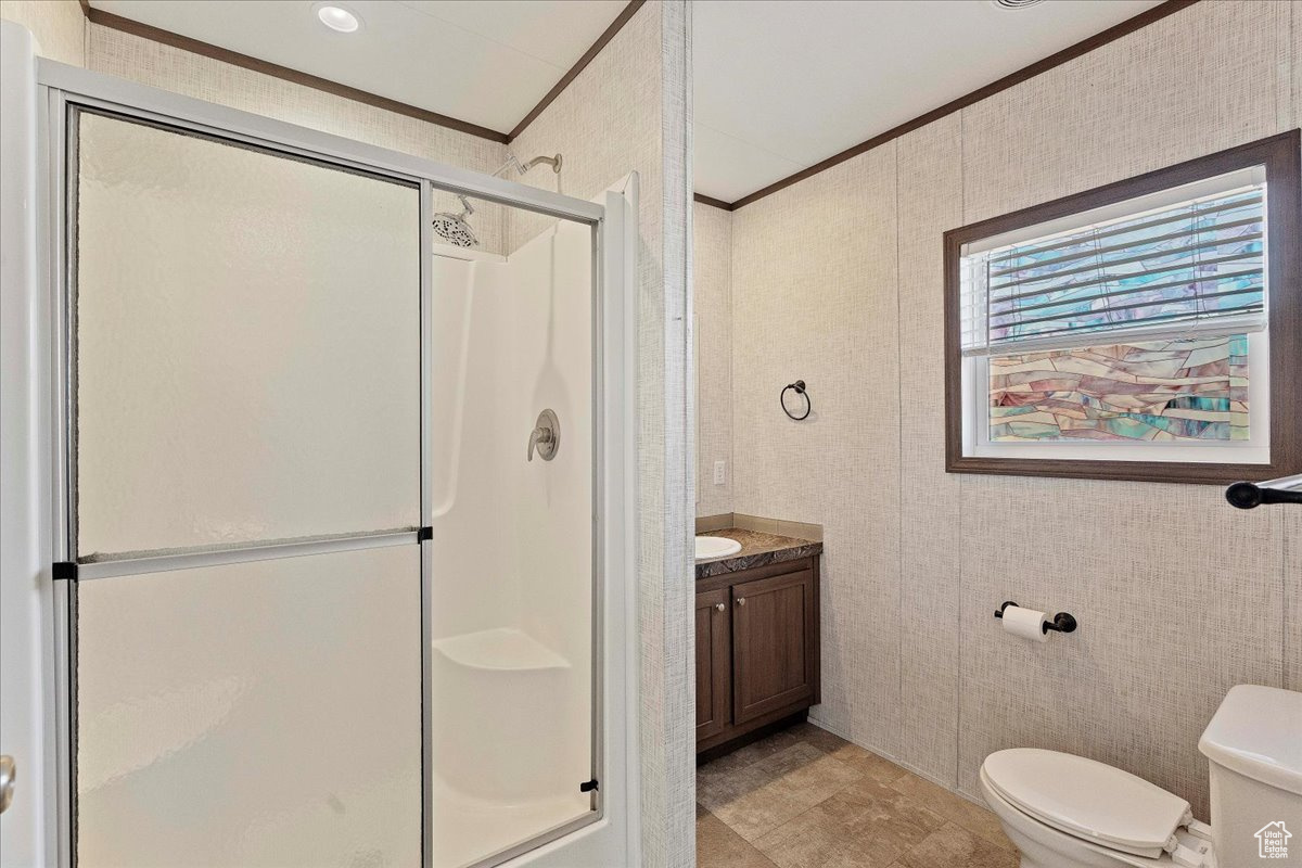 Bathroom with vanity, crown molding, toilet, and walk in shower