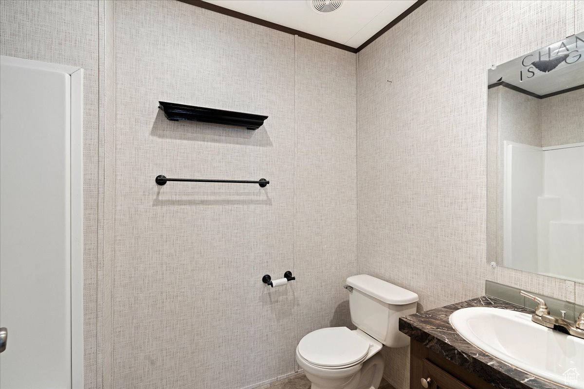 Bathroom with vanity, ornamental molding, and toilet