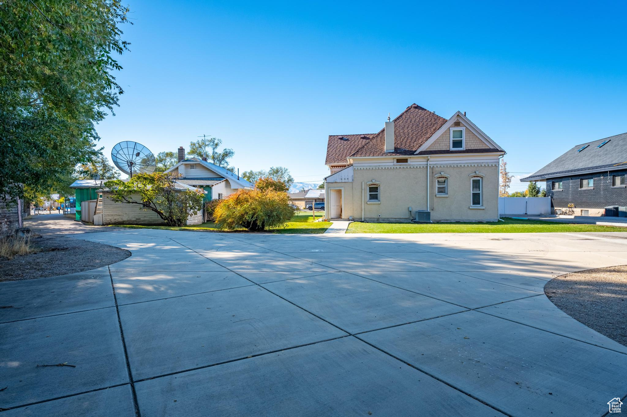 Rear view of house featuring cooling unit and a lawn