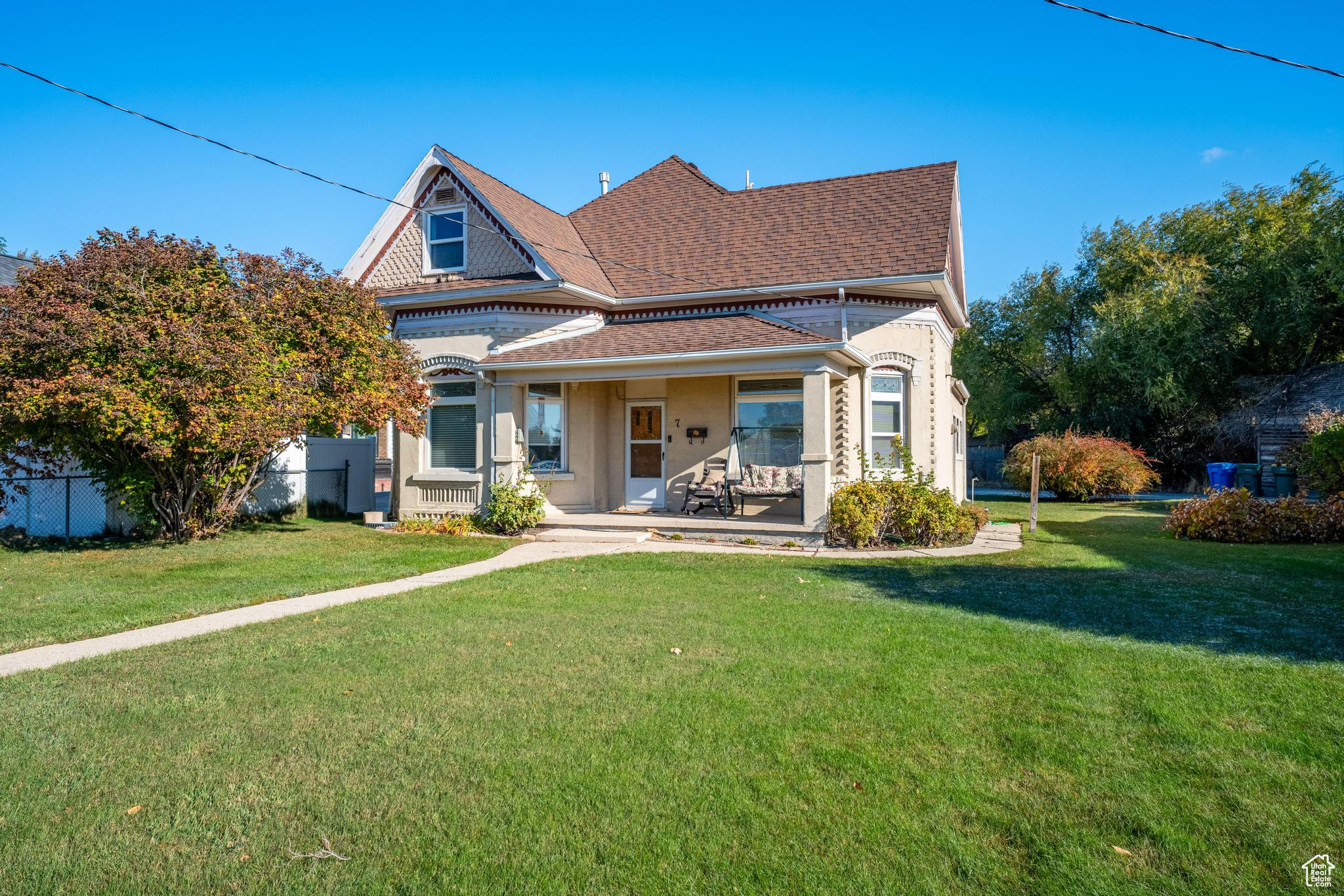 Rear view of house with a porch and a yard