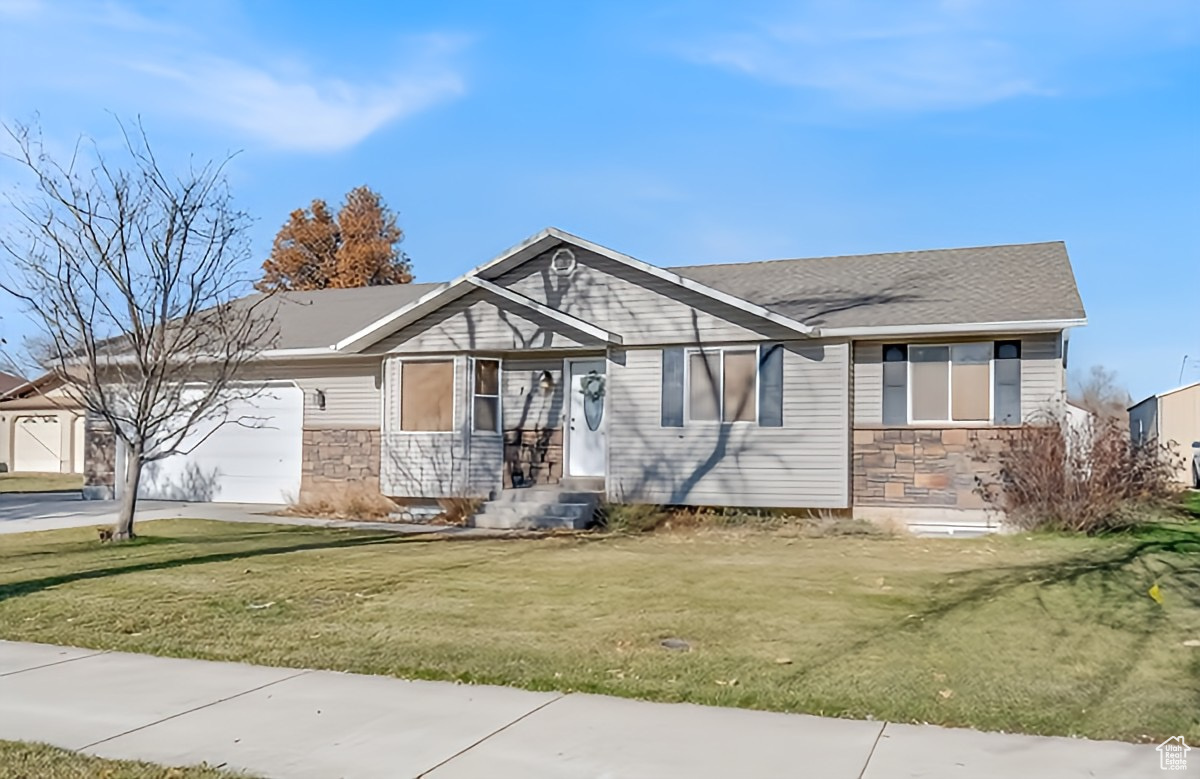 View of front facade with a front lawn and a garage