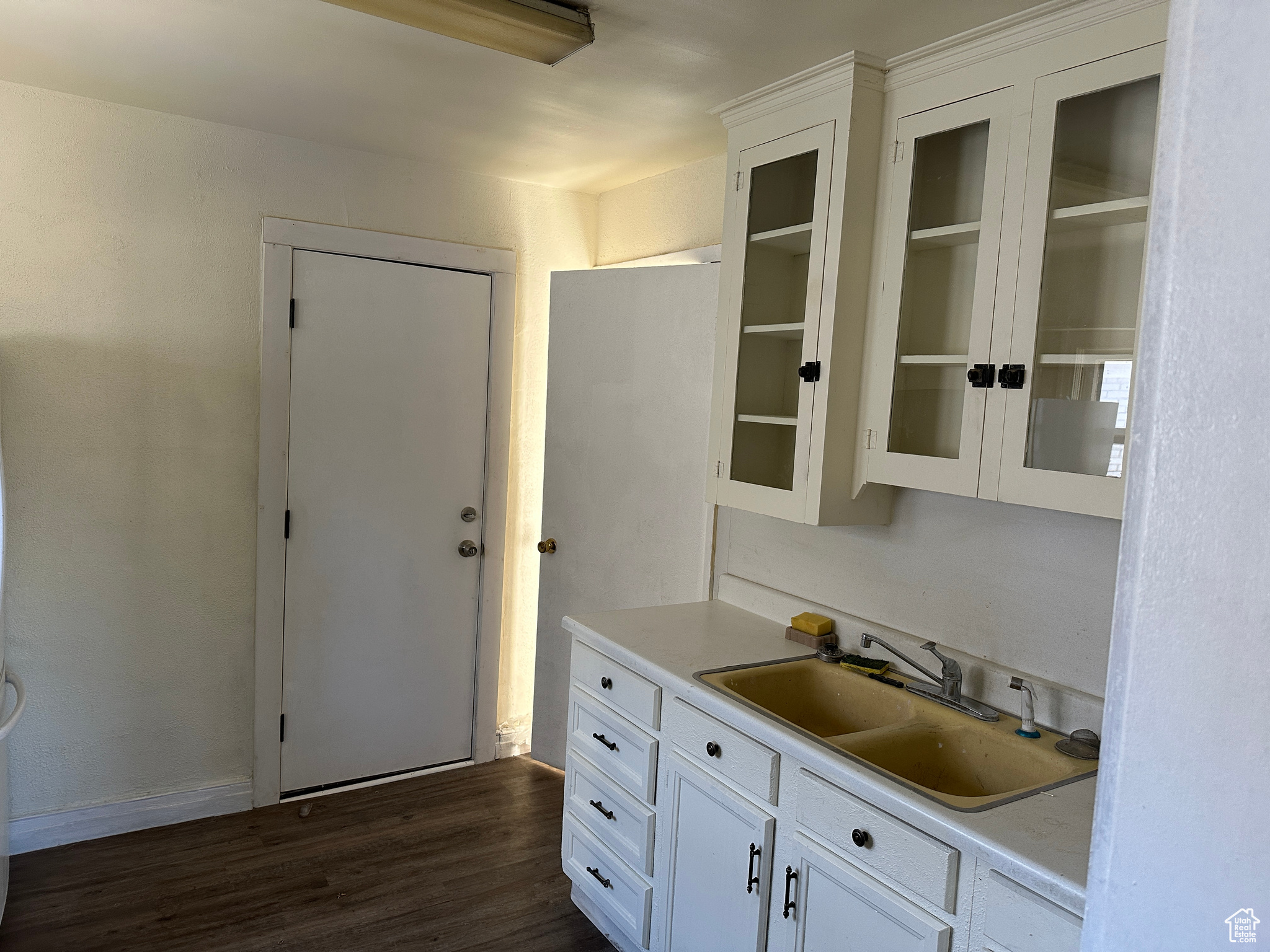 Kitchen with white cabinets, dark hardwood / wood-style flooring, and sink