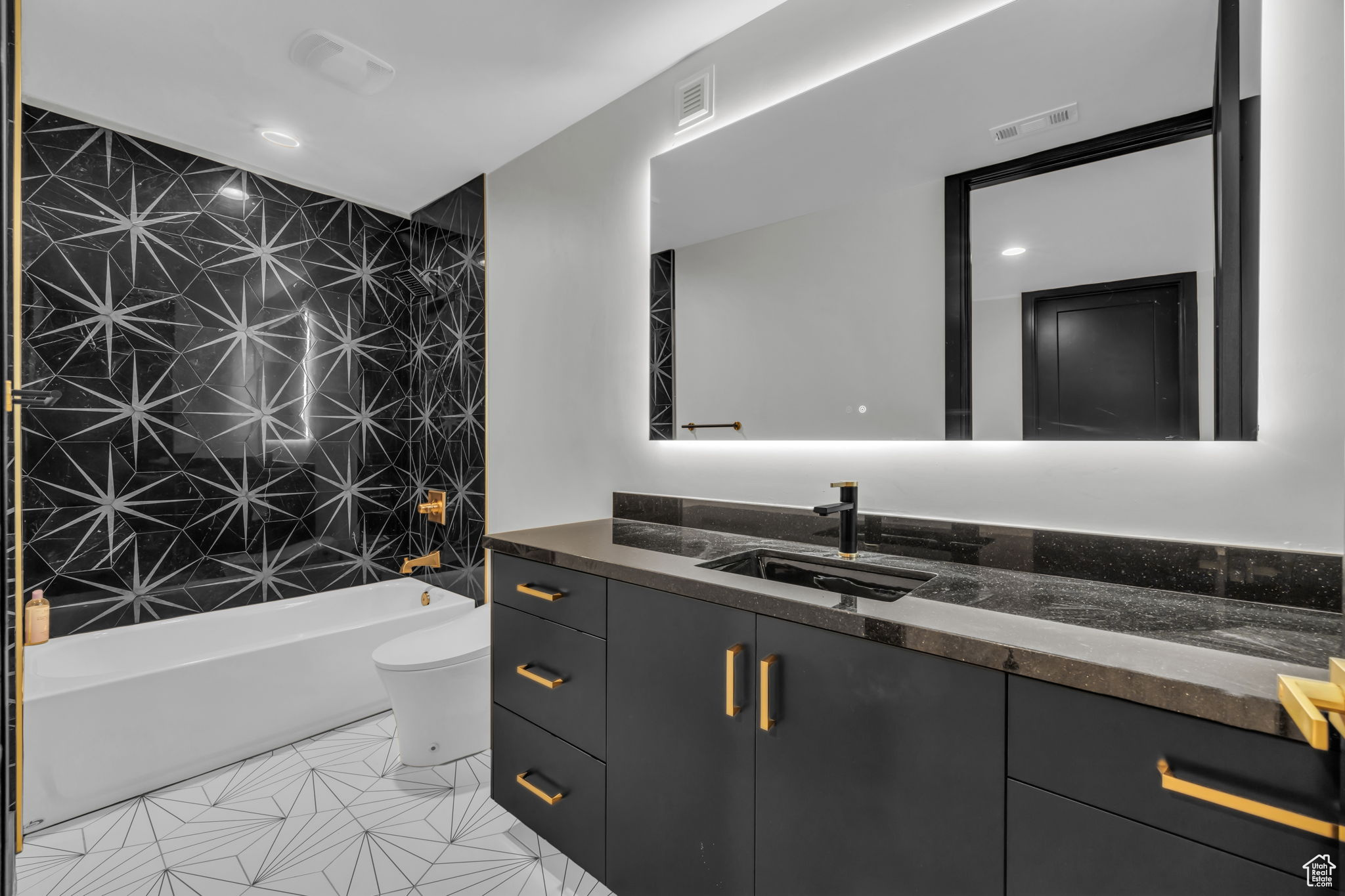 Full bathroom featuring tile patterned flooring, vanity, toilet, and tiled shower / bath