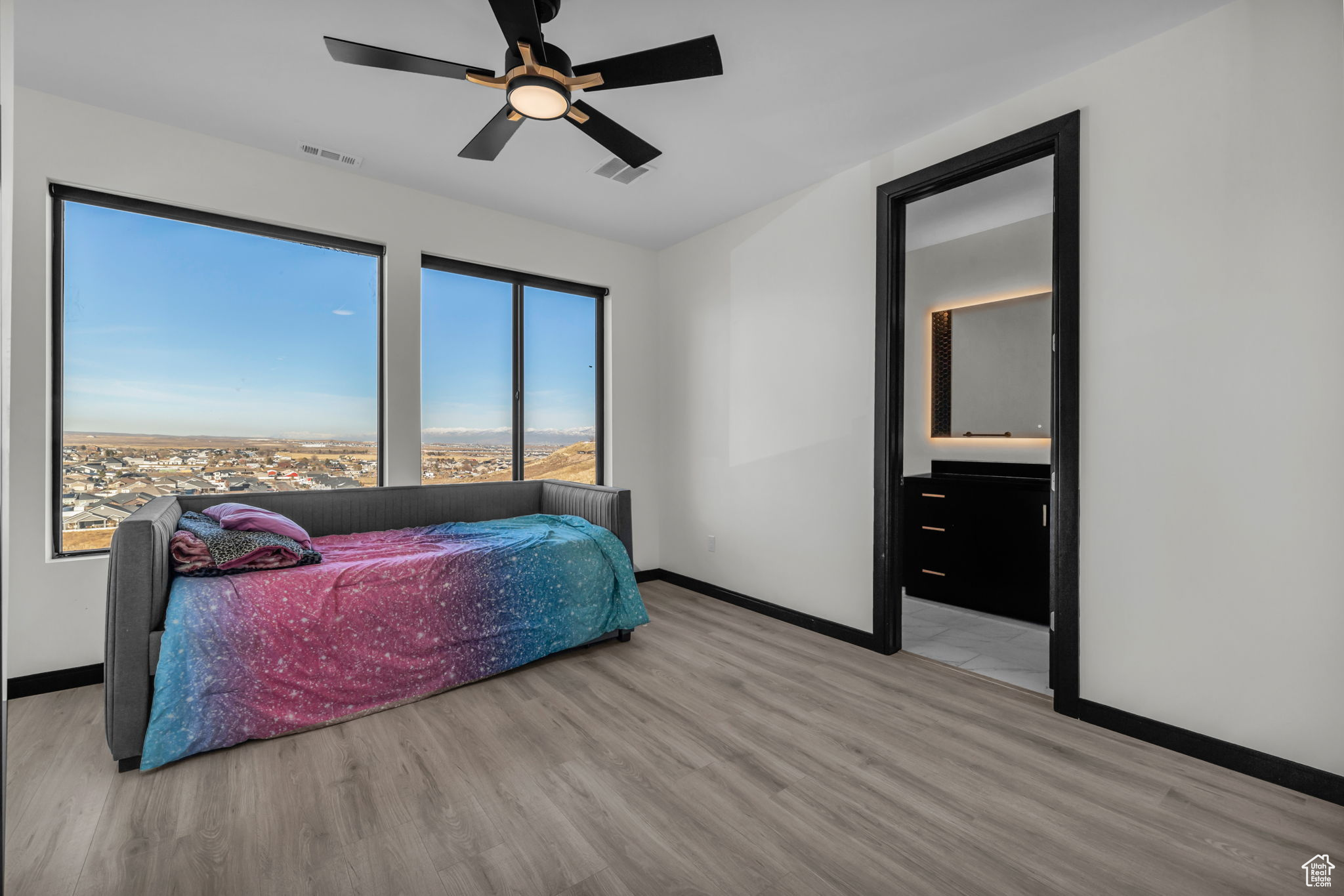 Bedroom featuring ceiling fan, light hardwood / wood-style floors, and ensuite bathroom