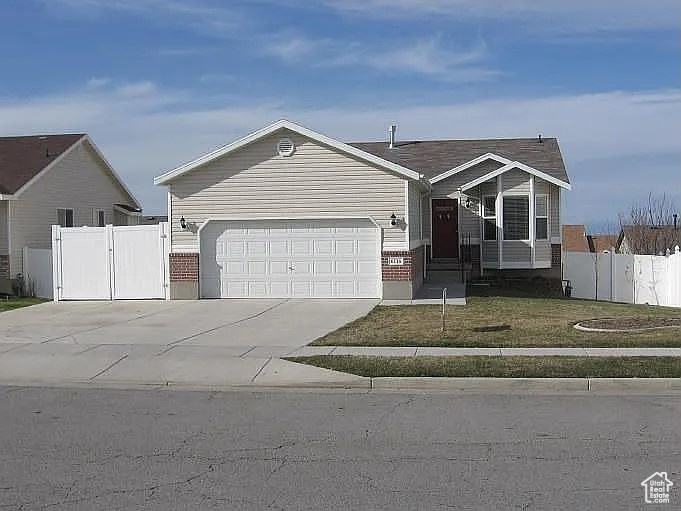 View of front of house featuring a front lawn and a garage