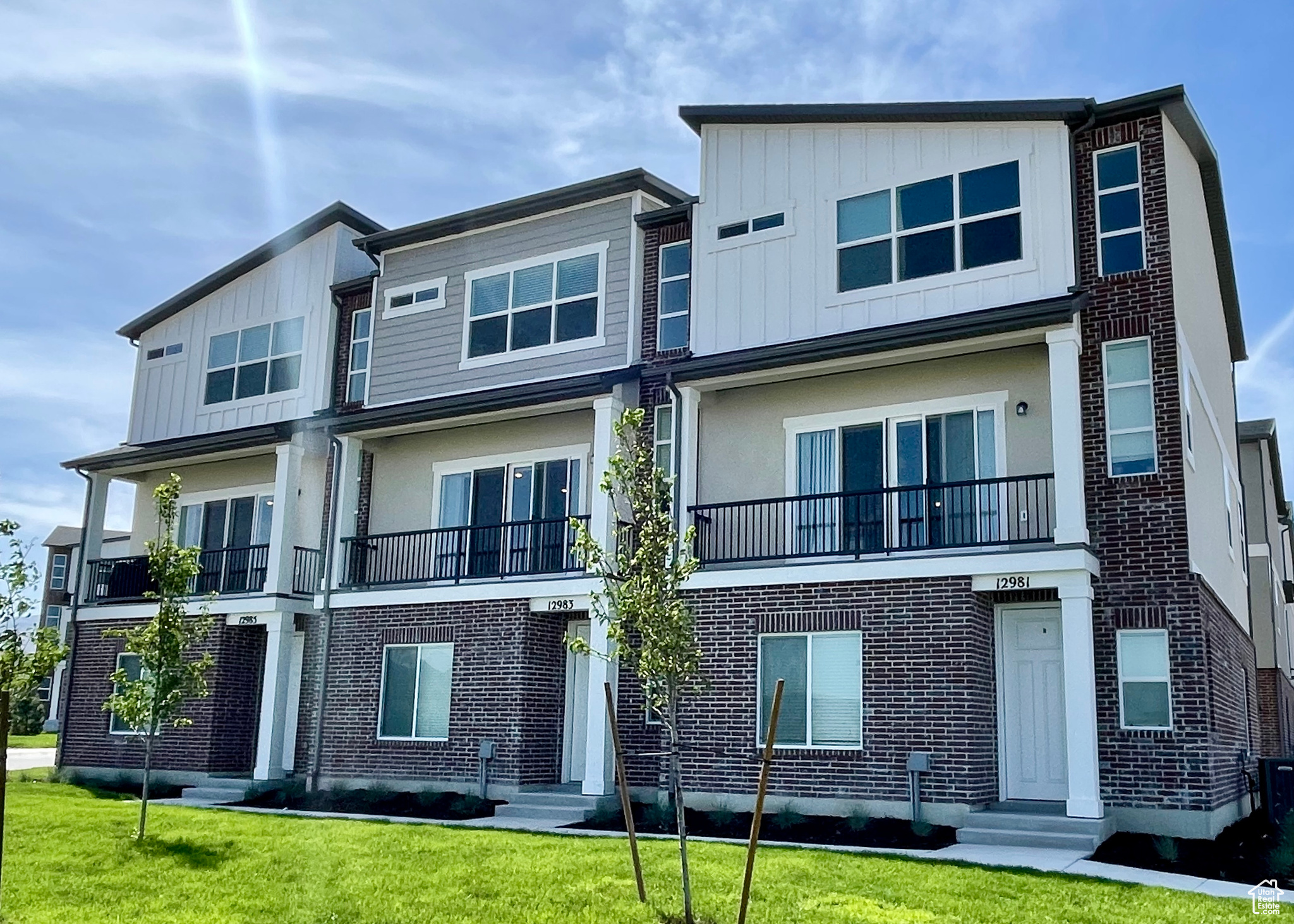 View of front of home featuring a balcony and a front lawn